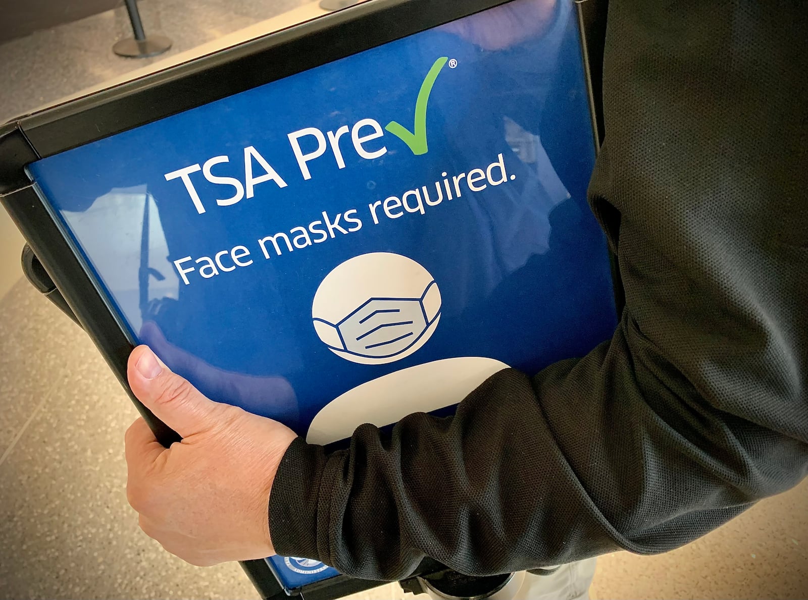 TSA employees remove Face mask required signs Tuesday April 19, 2022 at the Dayton International Airport. A federal judge struck down mask mandates for buses, planes and other public transportation. MARSHALL GORBY\STAFF