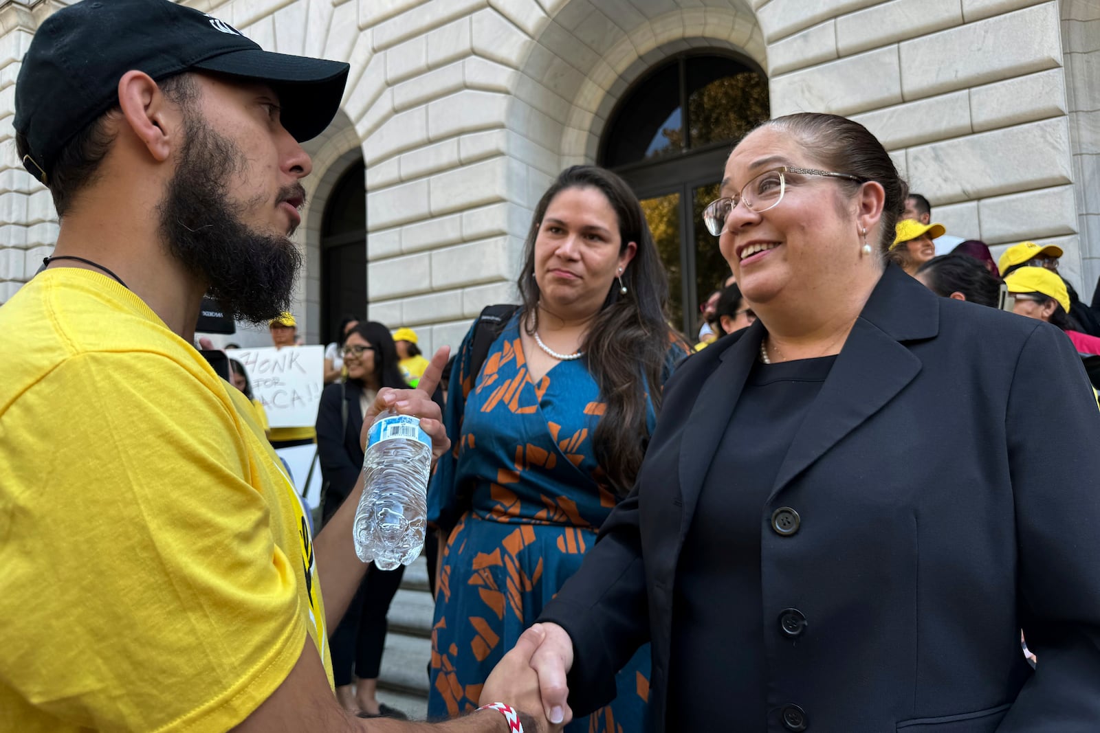 Attorney Nina Perales, vice president of litigation for the Mexican American Legal Defense and Educational Fund, shakes hands with a DACA supporter outside federal appellate court in New Orleans following a hearing to decide the policy's future on Thursday, Oct. 10, 2024. (AP Photo/Jack Brook)