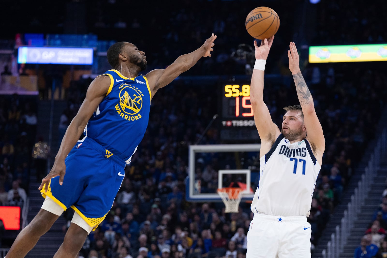 Golden State Warriors forward Andrew Wiggins (22) defends against Dallas Mavericks forward Luka Dončić (77) during the first half of an NBA basketball game Sunday, Dec. 15, 2024, in San Francisco. (AP Photo/Benjamin Fanjoy)