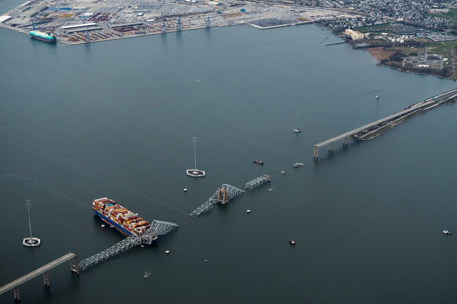 
                        An aerial view of the Dali container ship with a collapsed section of the Francis Scott Key Bridge across its bow after it collided with the bridge early Tuesday morning and the Dundalk Marine Terminal in the background in Baltimore, Md., on Tuesday, March 26, 2024. Six construction workers who had been fixing potholes on the Francis Scott Key Bridge remained missing as divers and other emergency workers on boats and helicopters continued to search for them. Two others had been rescued. (Erin Schaff/The New York Times)
                      