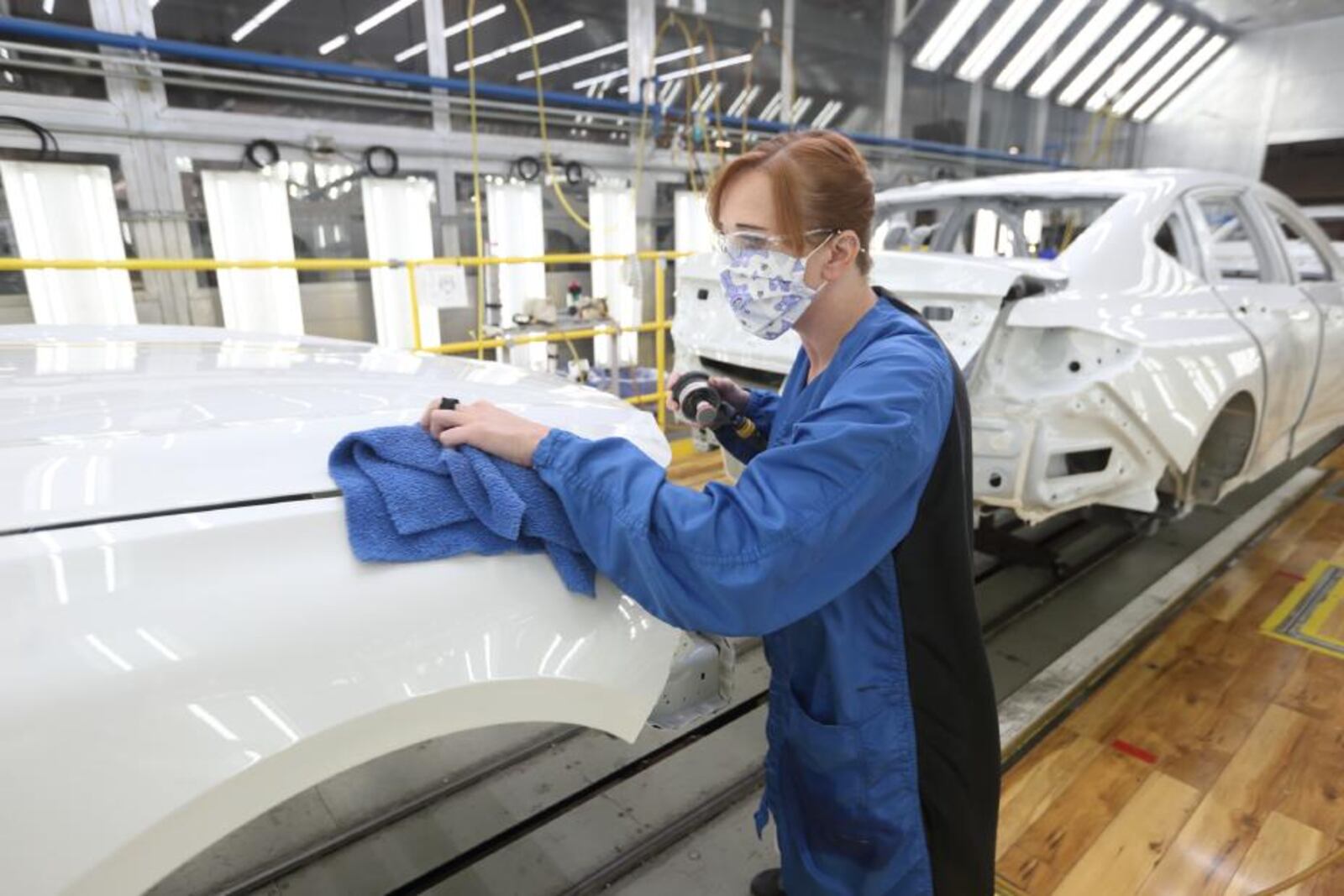 Honda employee Holly McMillen inspects the front end of an all-new Acura TLX built at the Marysville Auto Plant for paint quality. Contributed