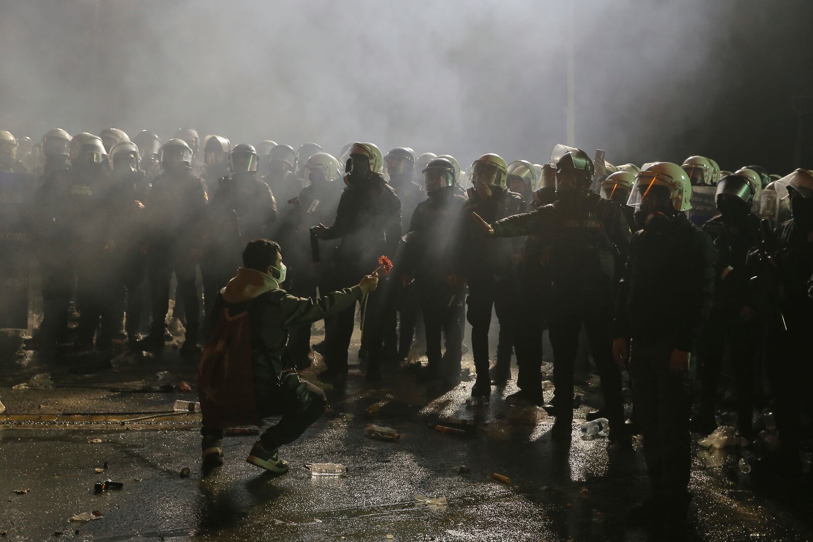 A protester gives a flower to riot police officers during a protest after Istanbul's Mayor Ekrem Imamoglu was arrested and sent to prison, in Istanbul, Turkey, Sunday, March 23, 2025. (AP Photo/Huseyin Aldemir)