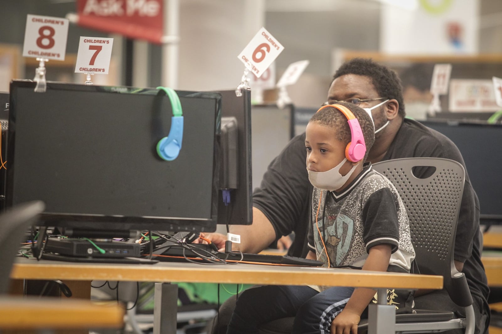 Cedric Jackson helps his nephew, Dolton Jackson at Dayton Library on Third St. in Dayton August 28, 2020.The COVID-19 pandemic caused state funding for public libraries to decrease for next year. Dayton Metro library's funding will drop more than $1.8 million.