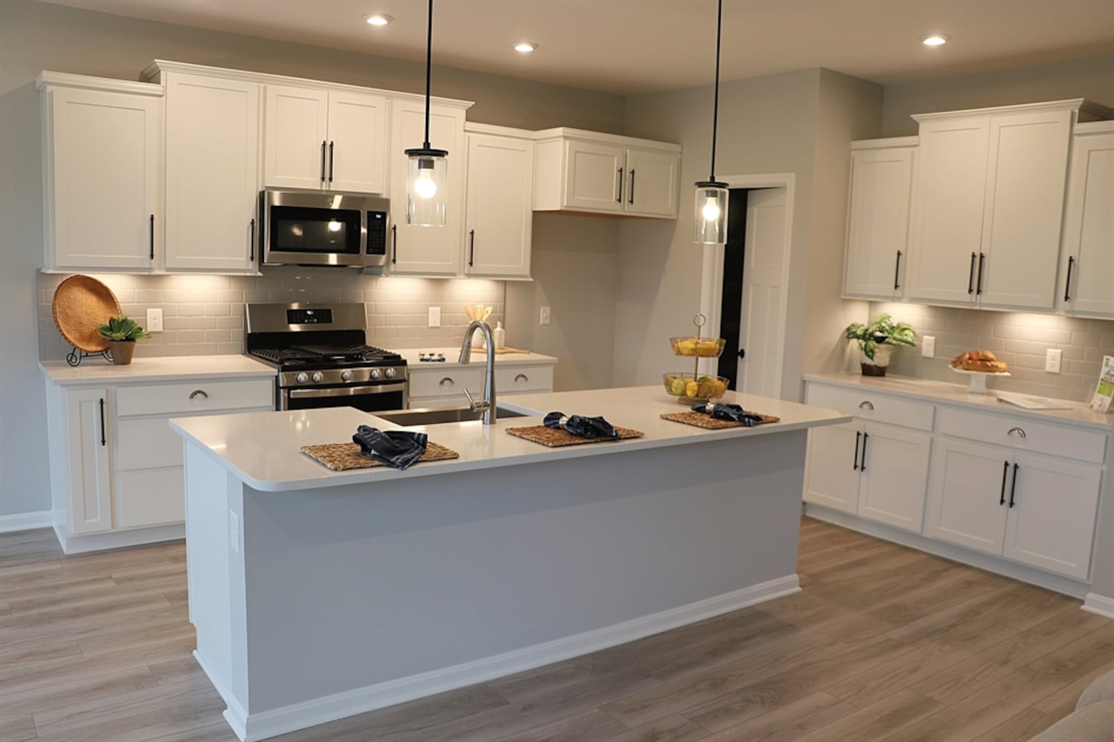 In the kitchen, an island has an extended quartz counter that allows for breakfast seating for up to four. 