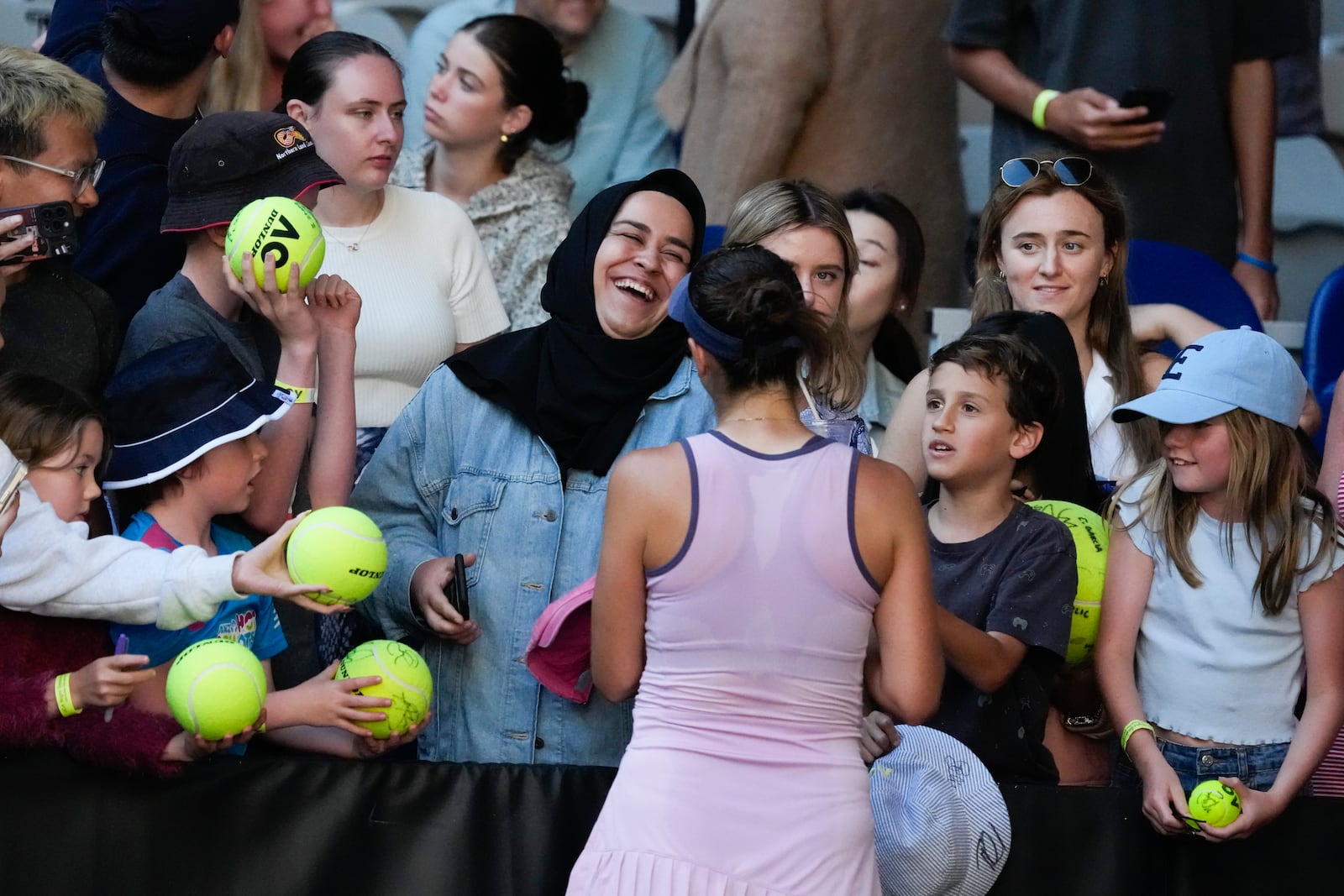 Belinda Bencic of Switzerland signs autographs following her third round match against Naomi Osaka of Japan at the Australian Open tennis championship in Melbourne, Australia, Friday, Jan. 17, 2025. (AP Photo/Manish Swarup)