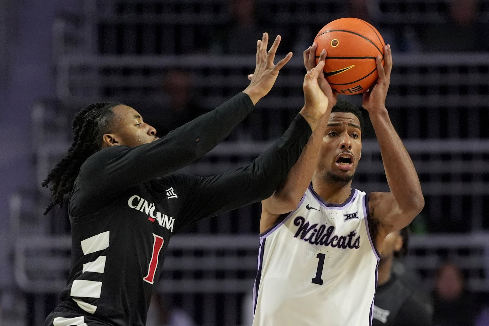 Kansas State guard David N'Guessan, right, looks to pass under pressure from Cincinnati guard Day Day Thomas, left, during the first half of an NCAA college basketball game, Monday, Dec. 30, 2024, in Manhattan, Kan. (AP Photo/Charlie Riedel)