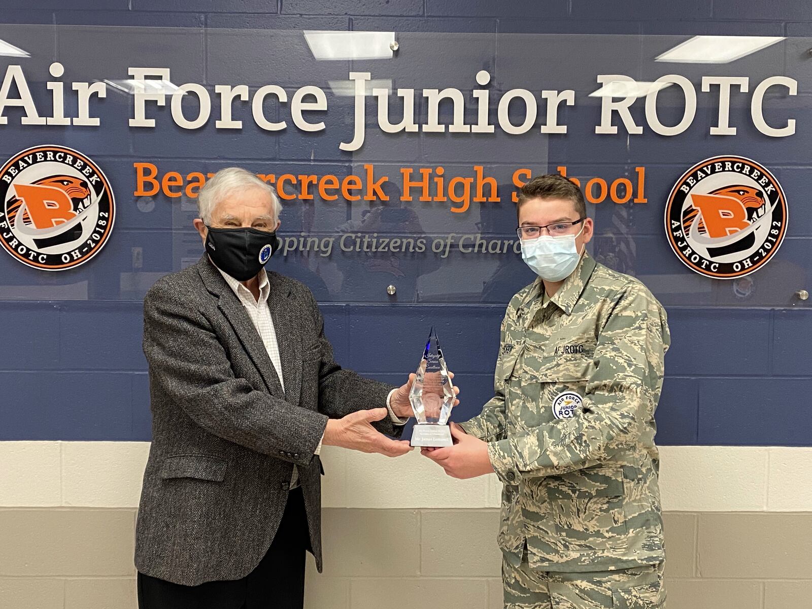 Air Force veteran Jim Lemanek is given an award for making desks for kids learning at home by Beavercreek Air Force ROTC student Craig Mackey. CONTRIBUTED