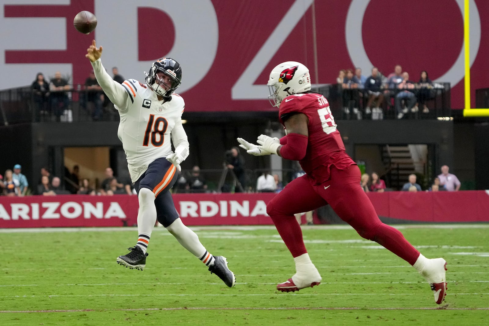 Chicago Bears quarterback Caleb Williams (18) throws as Arizona Cardinals defensive tackle Dante Stills defends during the first half of an NFL football game, Sunday, Nov. 3, 2024, in Glendale, Ariz. (AP Photo/Rick Scuteri)