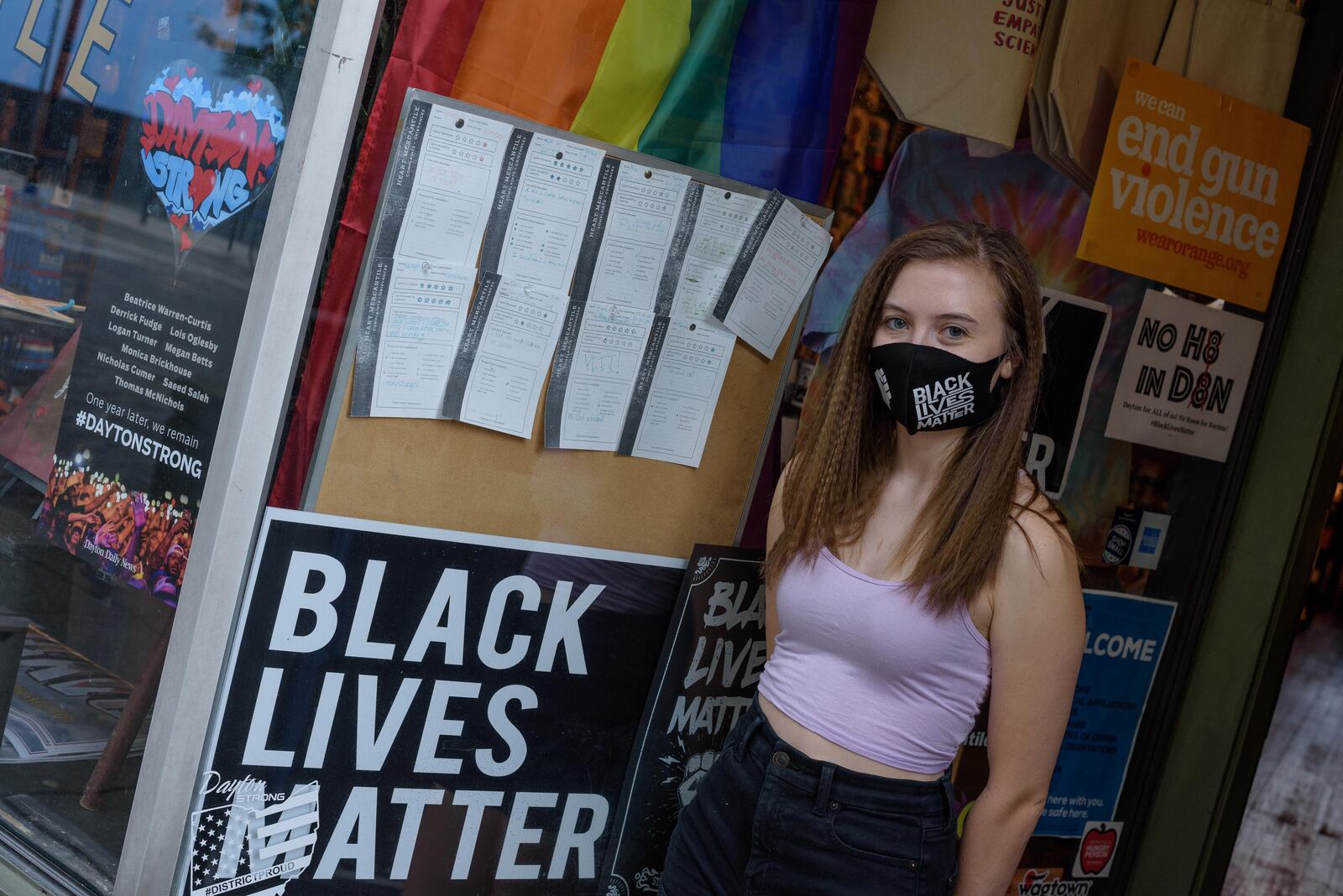 Tailor Curtis, Social Media Manager for Heart Mercantile, stands outside the Oregon District business with signs supporting the Black Lives Matter movement on Saturday, Aug. 1, 2020. TOM GILLIAM/CONTRIBUTED