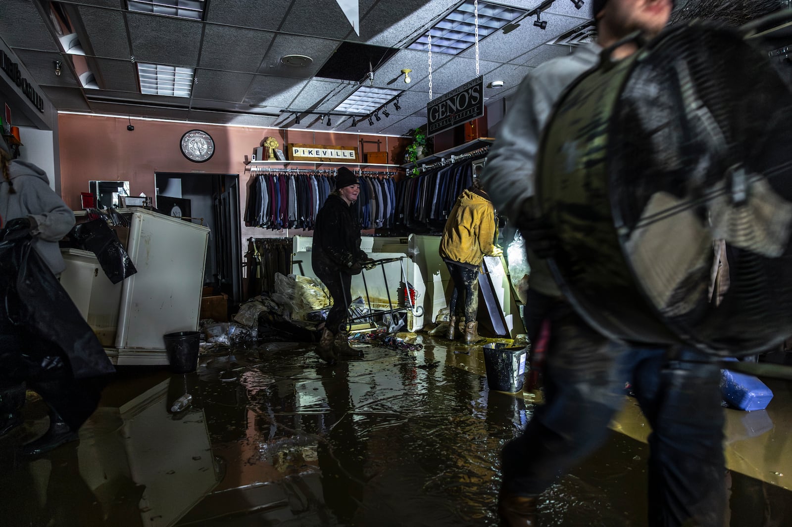 People work to recover clothing from The Men's Corner after flooding in Pike County, Ky., Tuesday, Feb. 18, 2025, following a storm the previous weekend. (Ryan C. Hermens/Lexington Herald-Leader via AP)