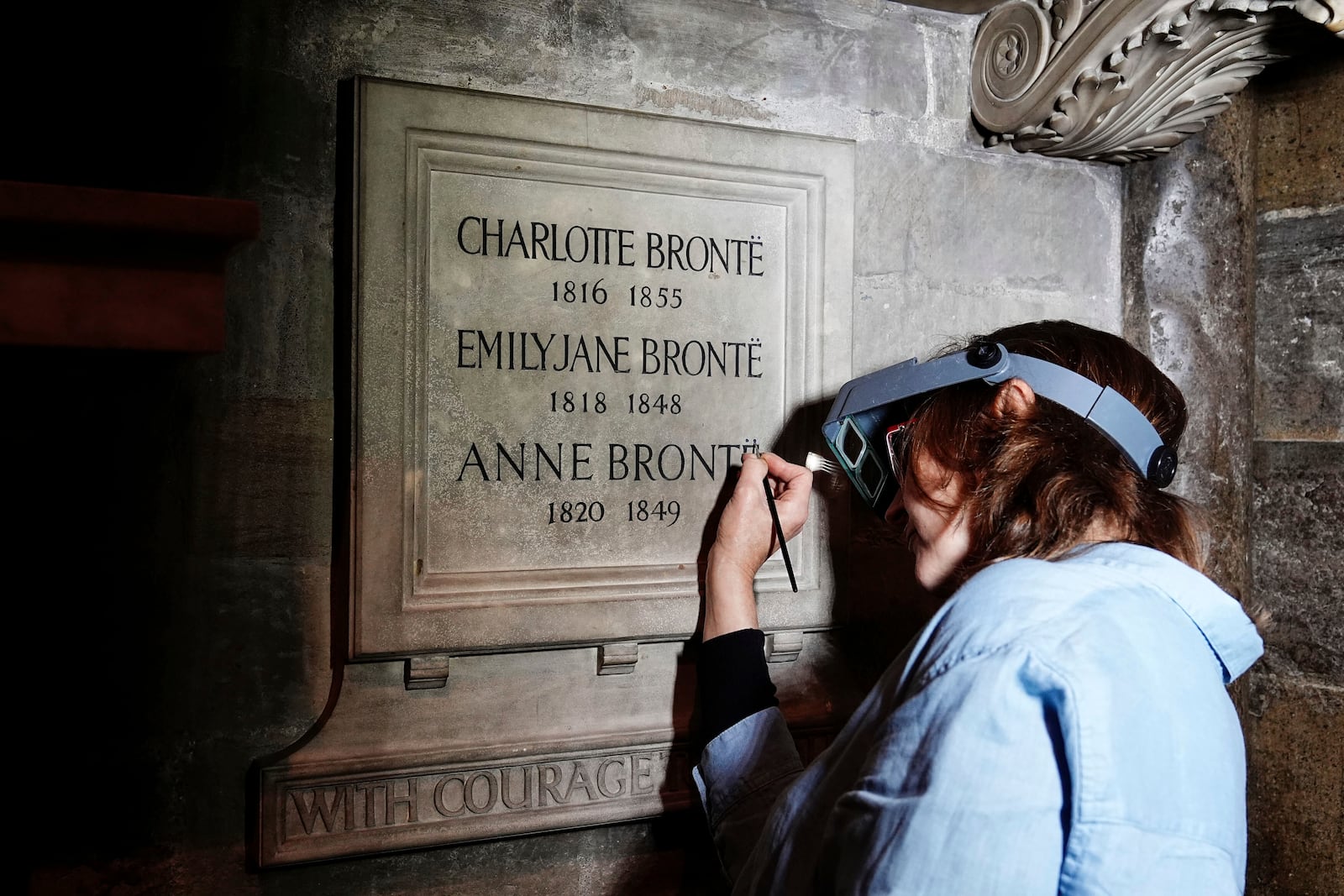 Conservator Lucy Ackland adds the finishing touches to the memorial to Charlotte, Emily and Anne Bronte at Poets' Corner in Westminster Abbey in London, England, Thursday Sept. 26, 2024. (Aaron Chown/PA via AP)