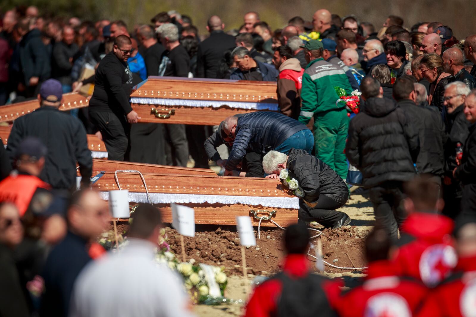 A person cries leaning on a coffin during the funeral ceremony of the victims of a massive nightclub fire in the town of Kocani, North Macedonia, Thursday, March 20, 2025. (AP Photo/Visar Kryeziu)