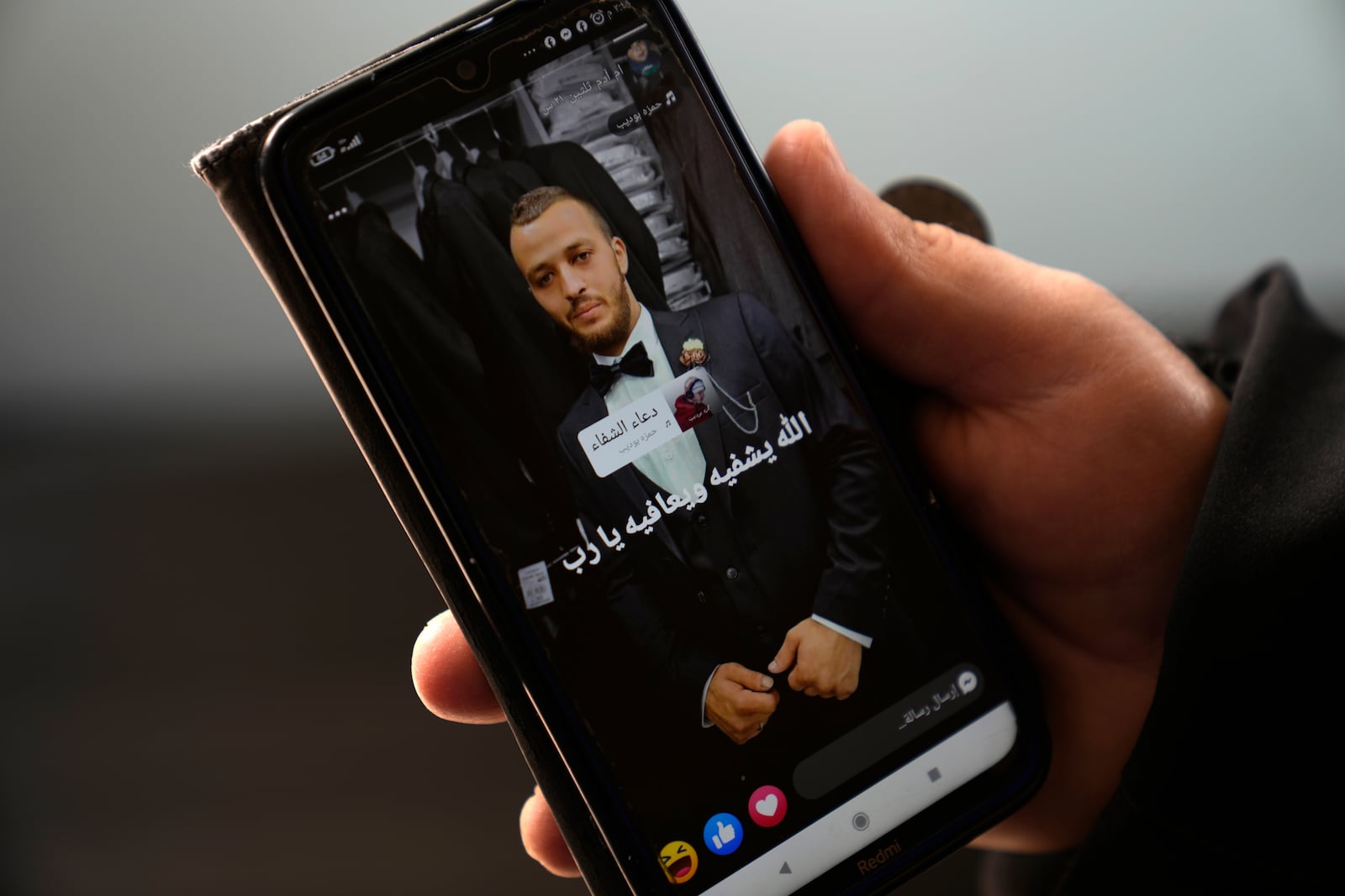 Mohammed Shula displays an undated picture of his son Yazan, while inside a relative's house where he and his wife have taken refuge at the West Bank village of Kafr al-Labad, Monday, Feb. 10, 2025. (AP Photo/Nasser Nasser)