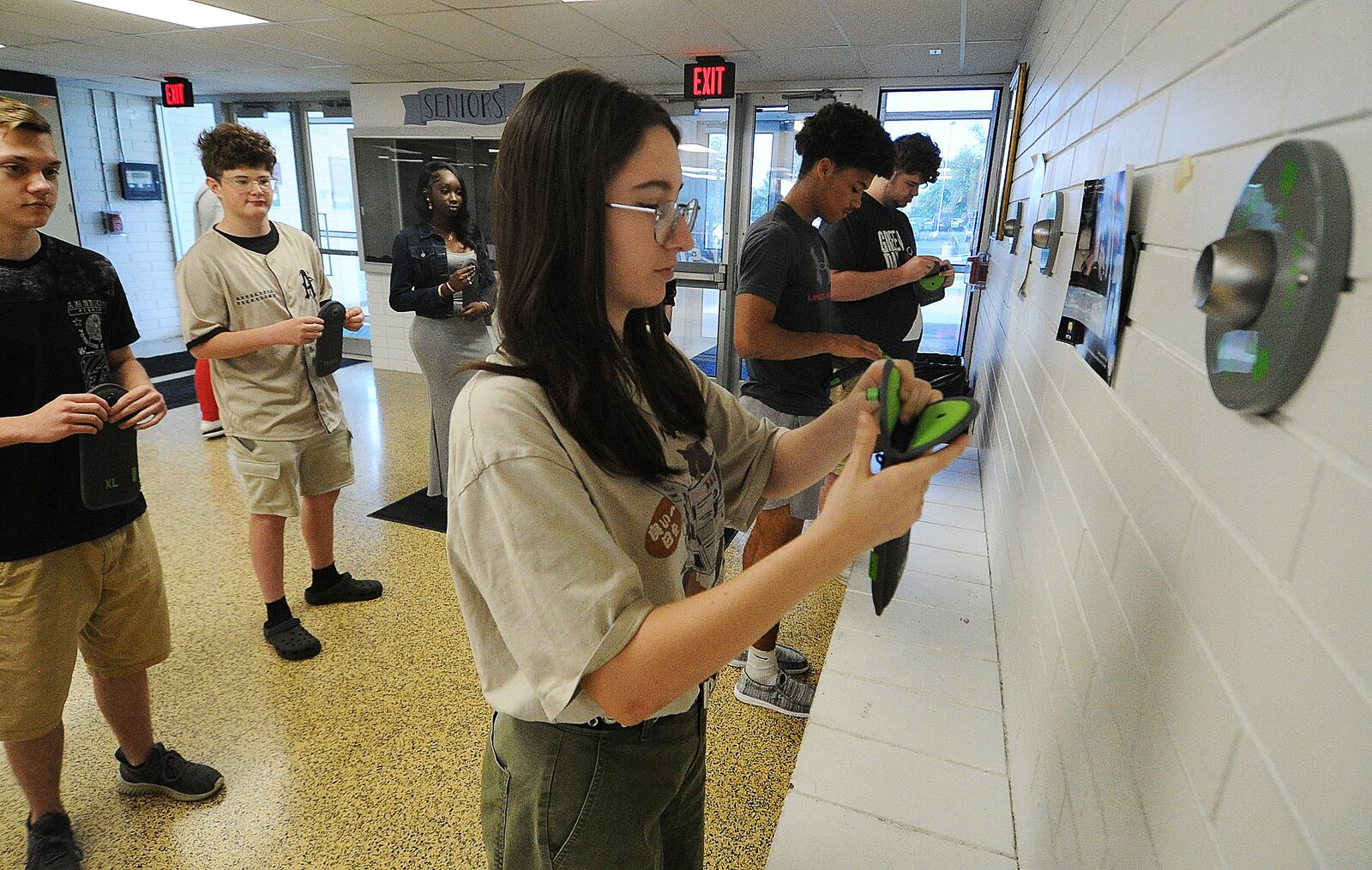 Fairborn High School students place their cell phones into pouches Thursday, May 23, 2024. Front row, left to right, Isabelle Fischer, Andrew Wilson and Travis Butts, back row from left Shane Walden, Clayton Finlay and Aita Samb. MARSHALL GORBY\STAFF