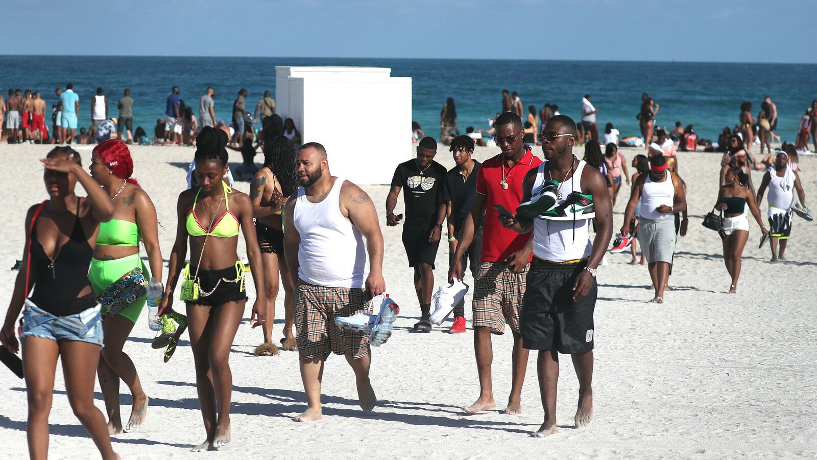 Beach goers make their way to the exit on South Beach March 15, 2020, as Miami Beach, Fla., officials close it to prevent the spread of coronavirus.