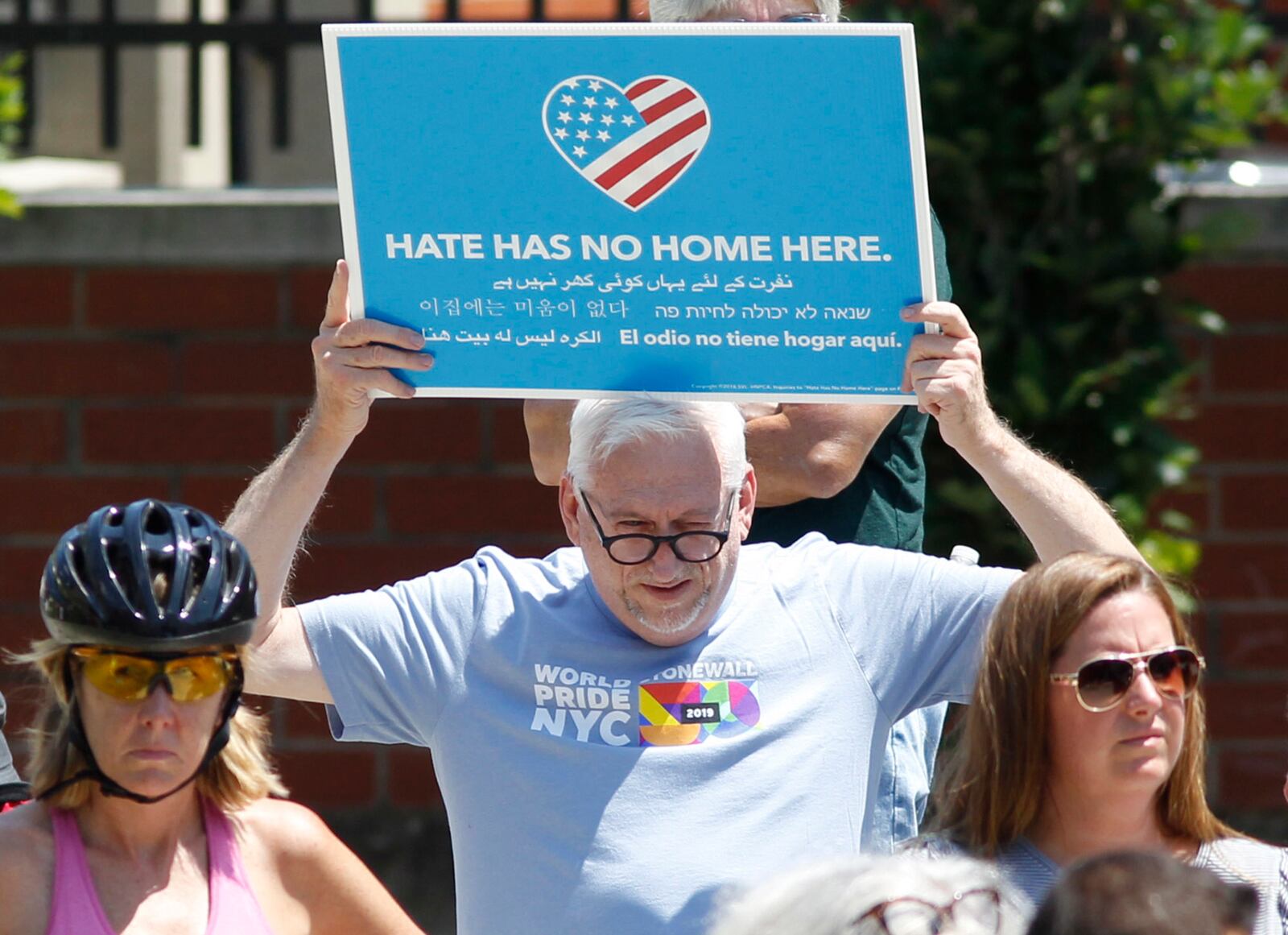 Prayer vigil attendees expressed their sadness and anger at Levitt Pavilion on Sunday afternoon after the Dayton shooting that claimed 10 lives including the shooter and injured more than two dozen others in the Oregon District at about 1 a.m. Sunday morning. Jerry Mallicoat from Miamisburg displayed this sign.  TY GREENLEES / STAFF