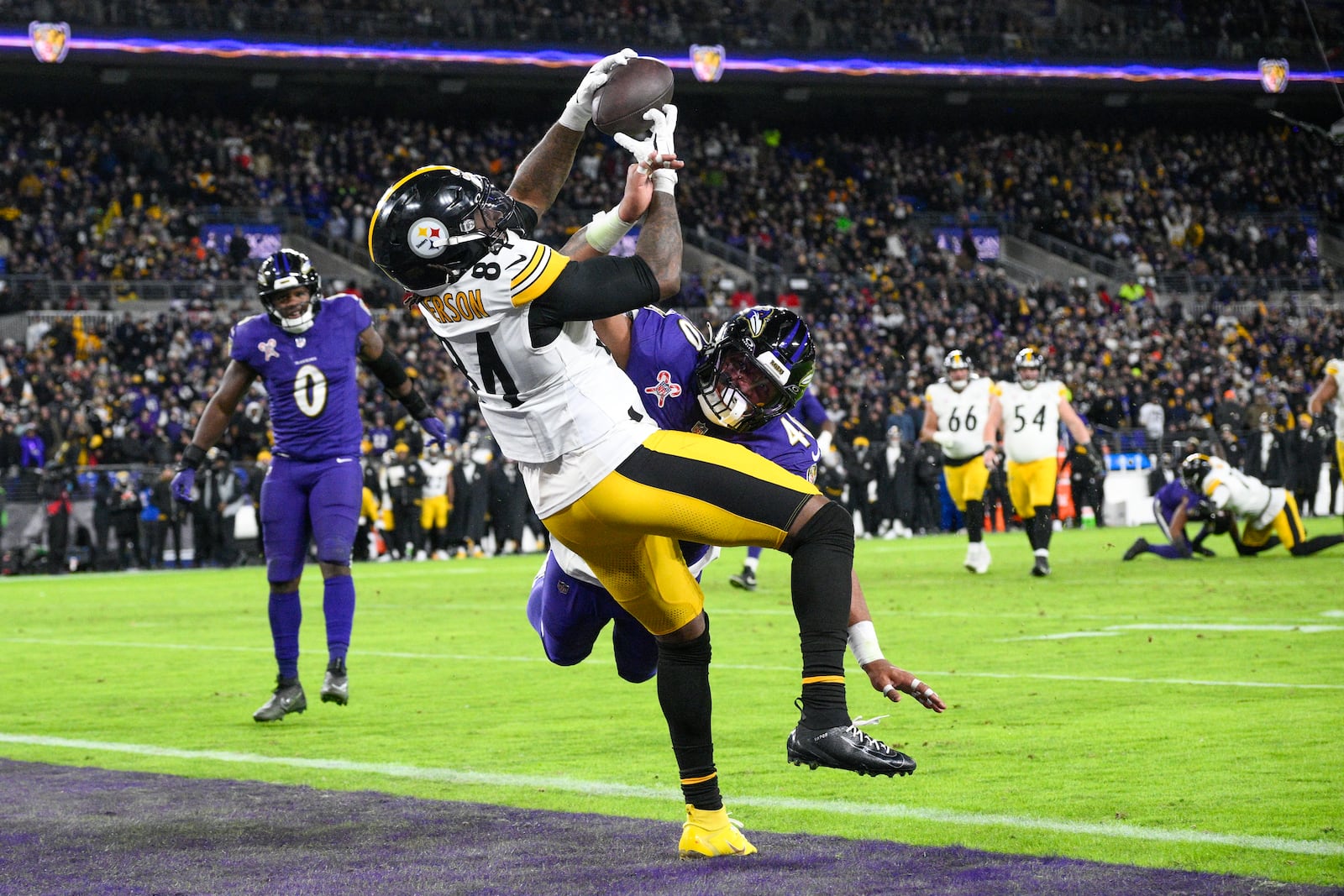 Pittsburgh Steelers running back Cordarrelle Patterson (84) catches a touchdown pass as Baltimore Ravens linebacker Malik Harrison defends during the second half of an NFL football game, Saturday, Dec. 21, 2024, in Baltimore. (AP Photo/Nick Wass)