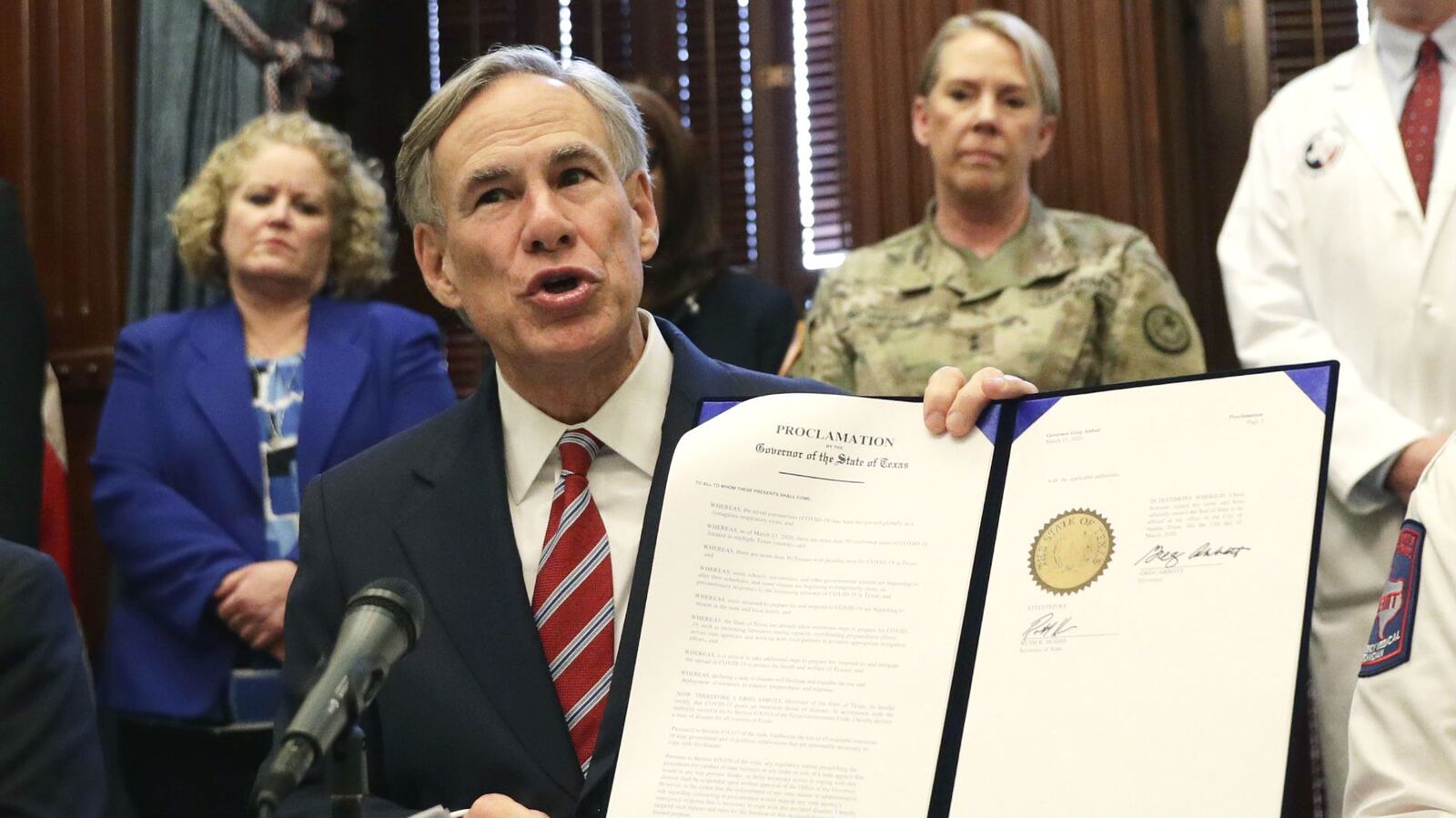 Texas Gov. Greg Abbott holds a proclamation as he gives an update on the coronavirus pandemic March 13, 2020, in Austin. One executive order Abbott issued, to halt the release of some inmates due to COVID-19, is being challenged in court.