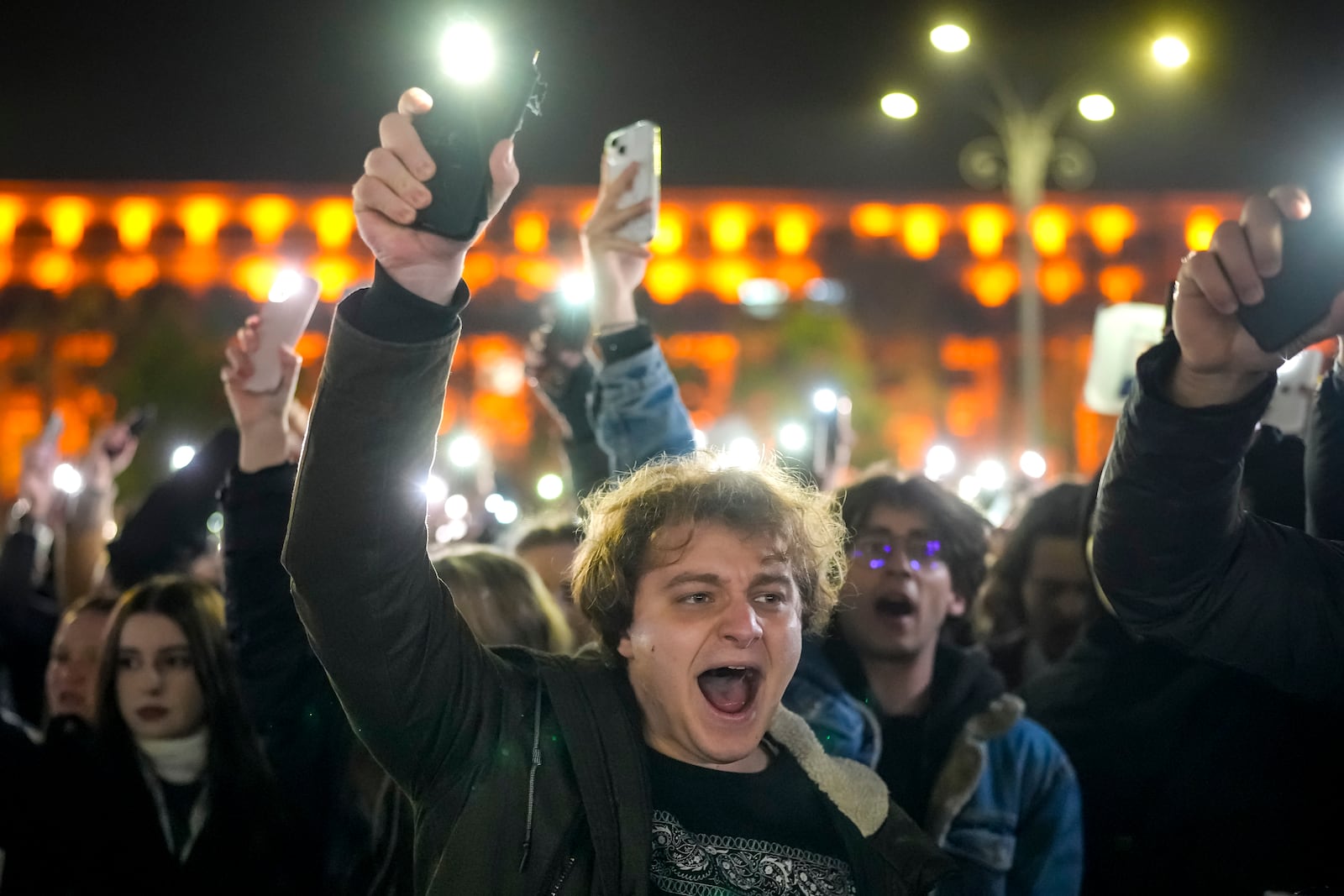 FILE - Youngsters shout slogans and flash the light of their mobile phones in Bucharest, Romania, Wednesday, Nov. 27, 2024, during a protest against Calin Georgescu, the independent candidate for Romanian presidency who won the first round of elections making it to the Dec. 8, runoff. (AP Photo/Vadim Ghirda, File)