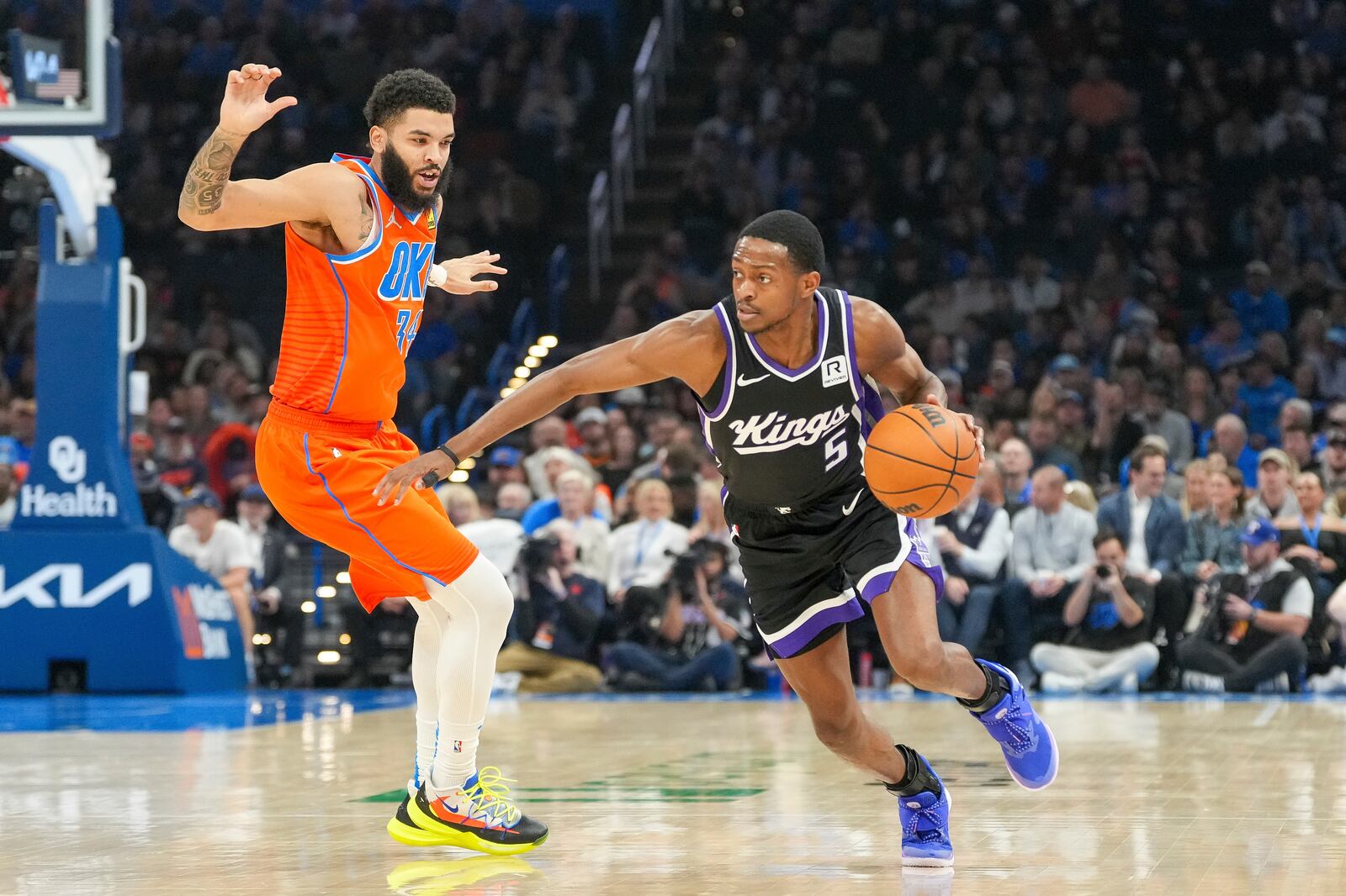 Sacramento Kings guard De'Aaron Fox, right, drives past Oklahoma City Thunder forward Kenrich Williams, left, during the first half of an NBA basketball game, Saturday, Feb. 1, 2025, in Oklahoma City. (AP Photo/Kyle Phillips)