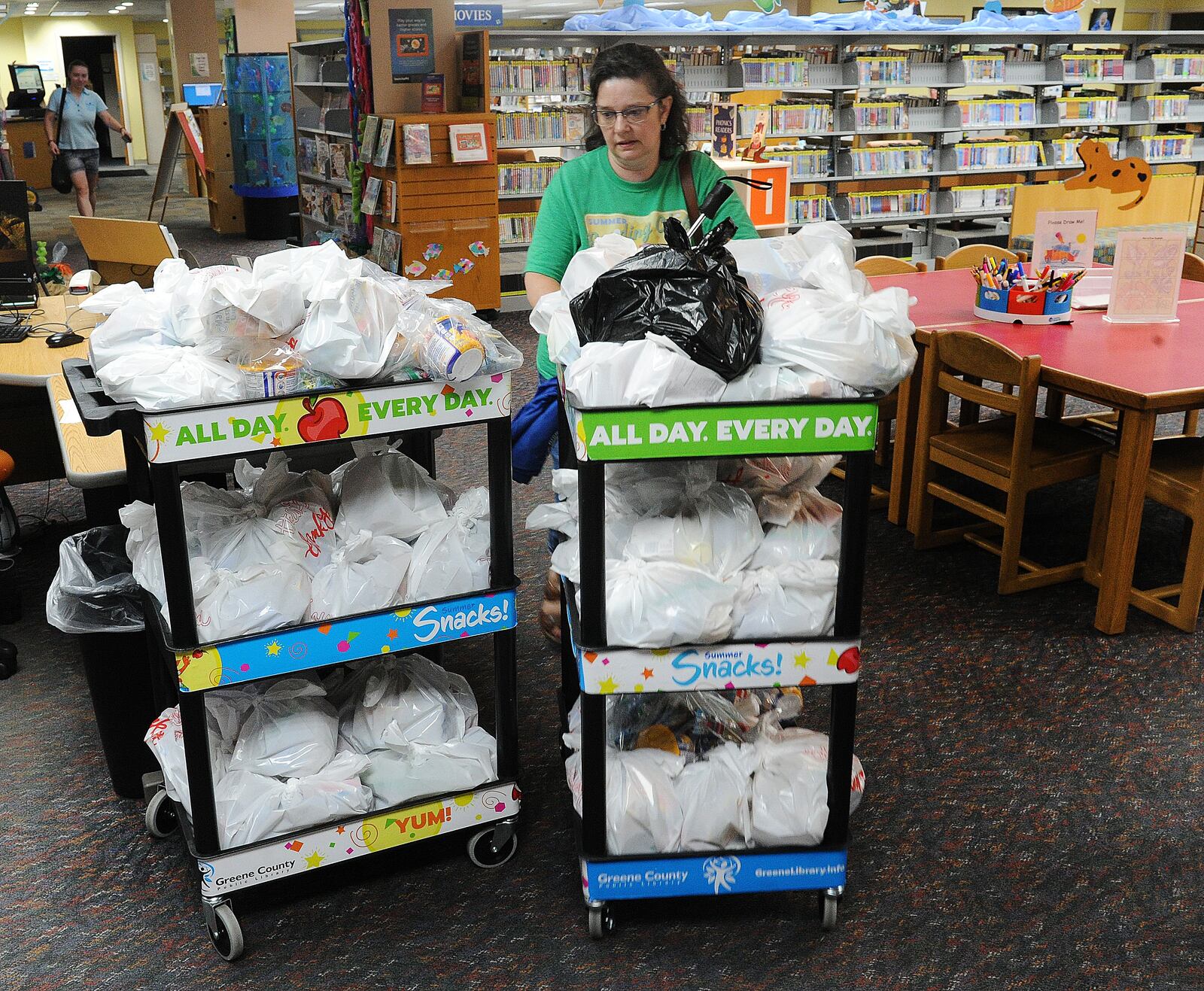 Youth Services Coordinator at the Greene County Public Library Kim Bautz delivers bags of snacks at the Xenia library, Tuesday 14, 2022. MARSHALL GORBY\STAFF