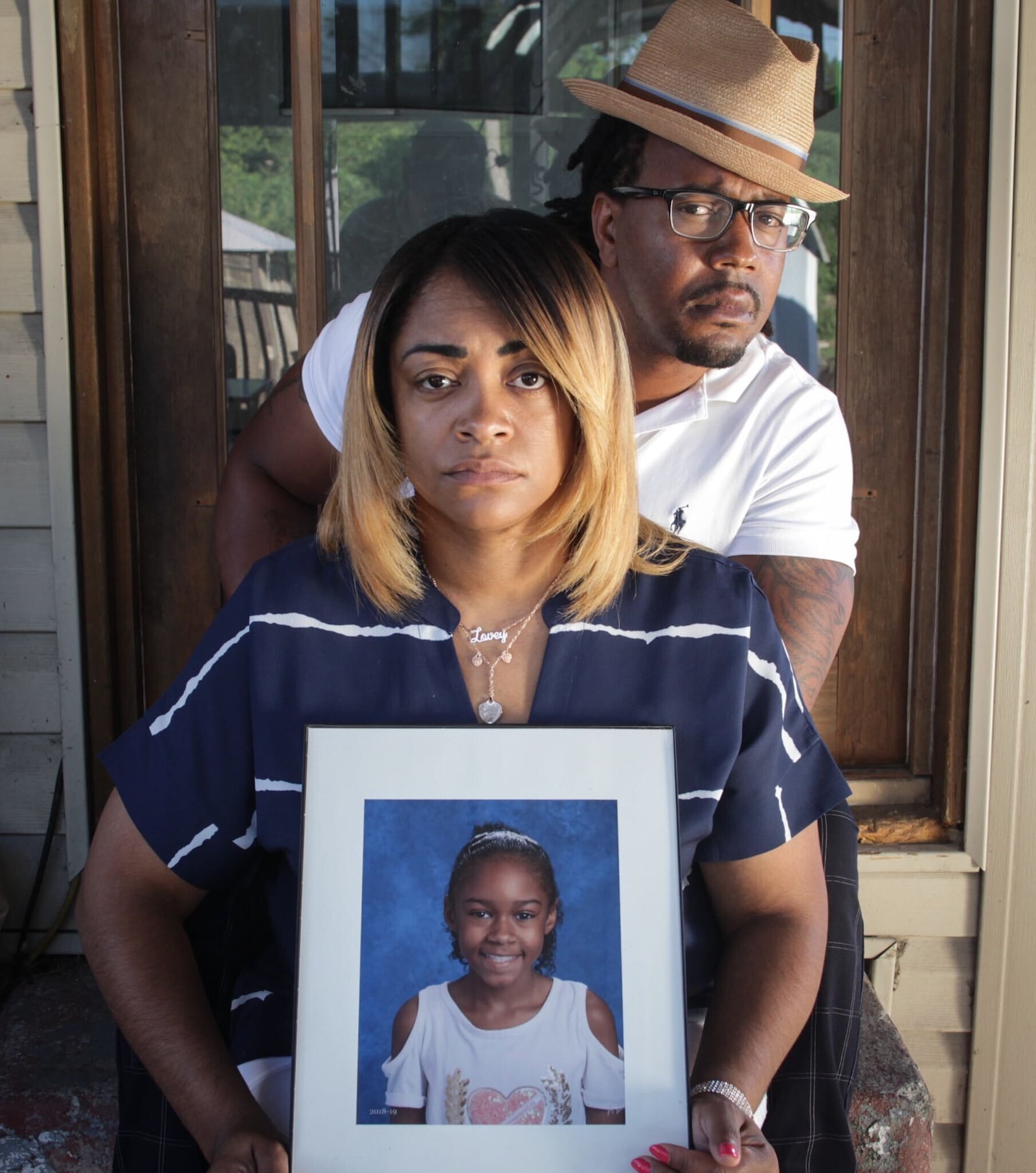 Dion Green lost his father, Derrick Fudge, in the Oregon District mass shooting a year ago. Donita Cosey holds a picture of their daughter,Niara Green, because she was out of town for the family photograph. “My dad died in my arms that night,” Dion said. Jim Noelker/Staff