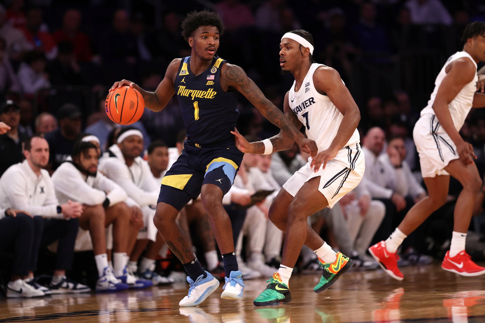 Marquette guard Kam Jones (1) dribbles the ball against Xavier guard Ryan Conwell (7) during the first half of an NCAA college basketball game in the quarterfinals of the Big East Conference tournament, Thursday, March 13, 2025, in New York. (AP Photo/Pamela Smith)