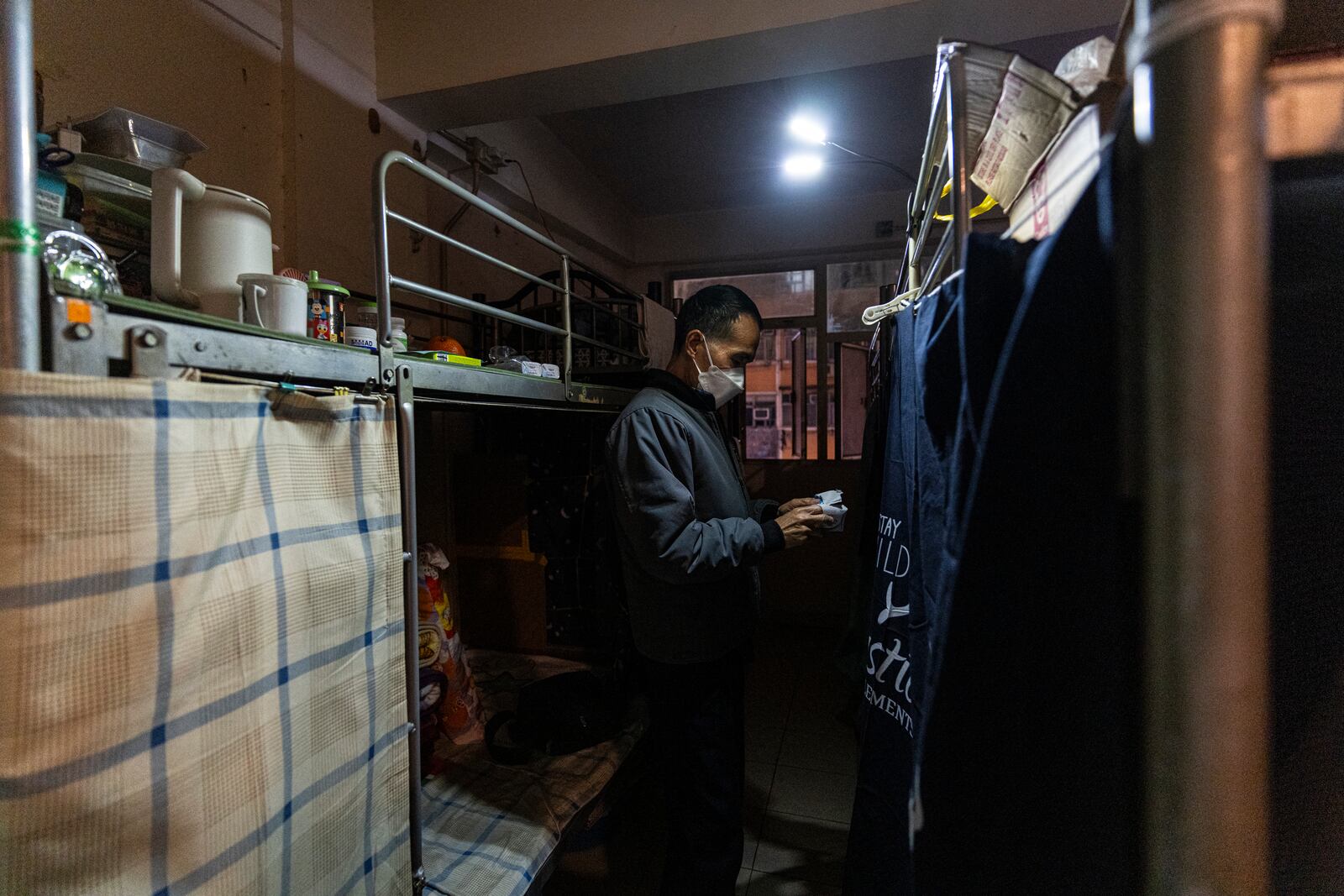 Resident Chung Shing-sun stands near his bed space in Sham Shui Po district of Hong Kong, on Feb. 6, 2025. (AP Photo/Chan Long Hei)