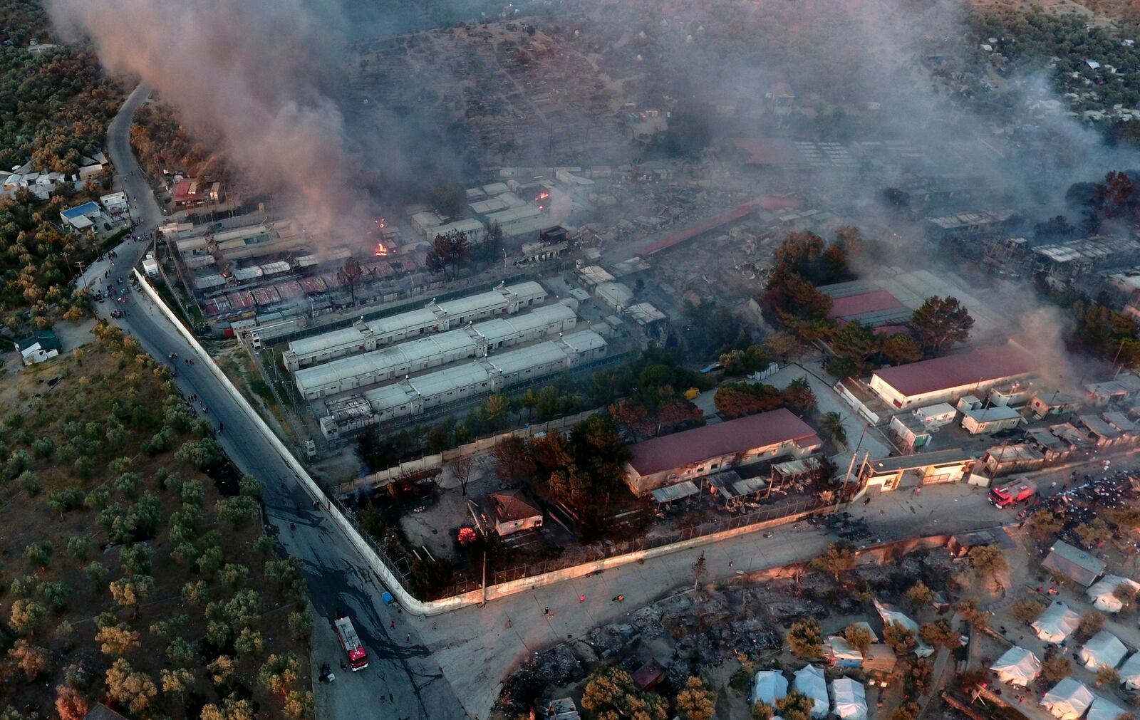 Fire burns container houses and tents in the Moria refugee camp on the northeastern Aegean island of Lesbos, Greece, on Wednesday, Sept. 9, 2020. A fire swept through Greece's largest refugee camp that had been placed under COVID-19 lockdown, leaving more than 12,000 migrants in emergency need of shelter on the island of Lesbos. (AP Photo/Panagiotis Balaskas)