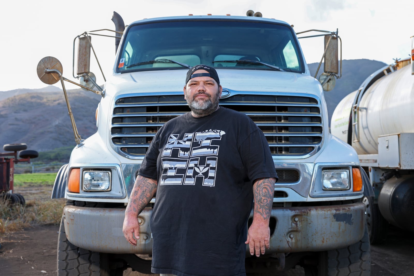 Joshua Kamalo, 43, stands by a truck he drives for work Wednesday, Dec. 18, 2024, in Maalaea, Hawaii. (AP Photo/Marco Garcia)