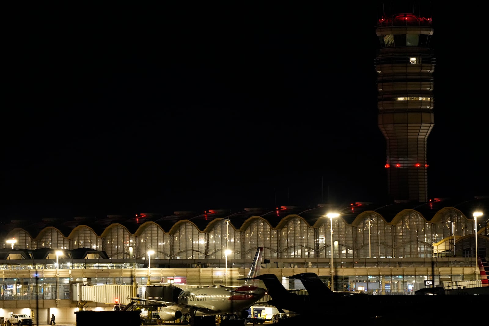 An American Airlines plane is parked at a gate at Ronald Reagan Washington National Airport, Wednesday, Jan. 29, 2025, in Arlington, Va. (AP Photo/Mark Schiefelbein)