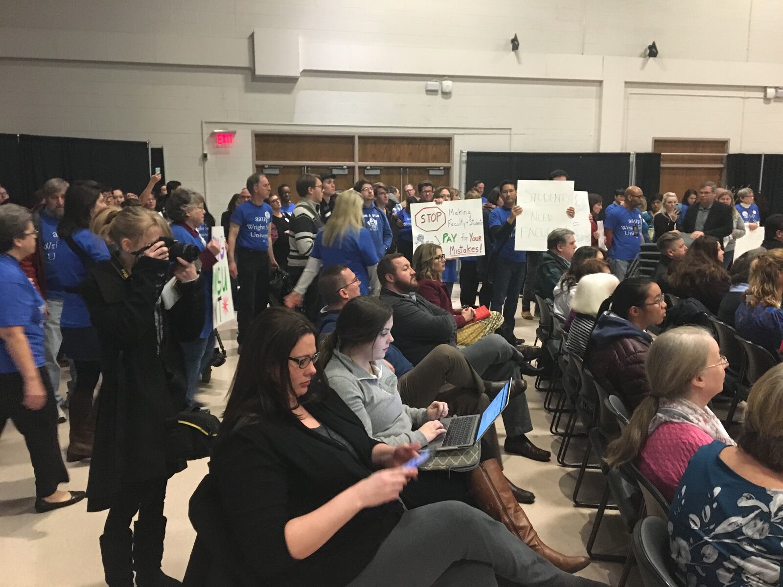 Wright State University faculty union members held signs in the back of a budget forum in January to protest a contract offer from the administration. Contract talks are ongoing but the faculty union as threatened to strike if a deal is not reached.