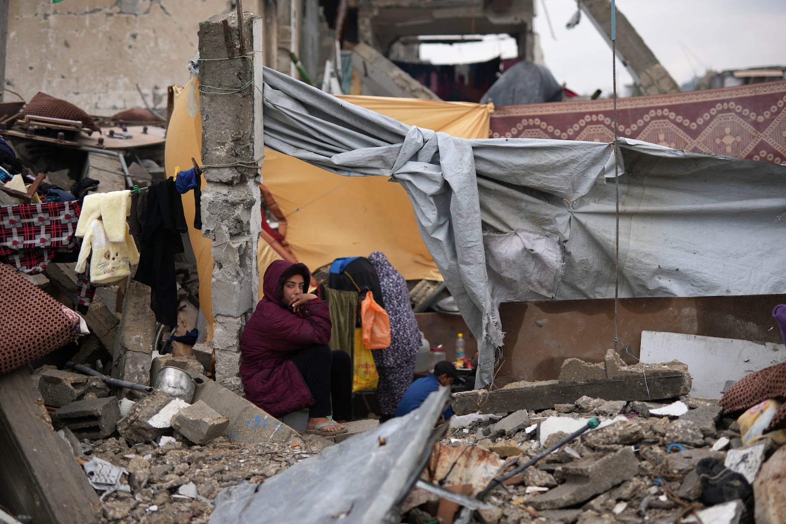 The Rehan family in their encampment in the ruins of their home amid widespread destruction caused by the Israeli military's ground and air offensive in Jabaliya, Gaza Strip, Monday, Feb. 10, 2025. (AP Photo/Abdel Kareem Hana)