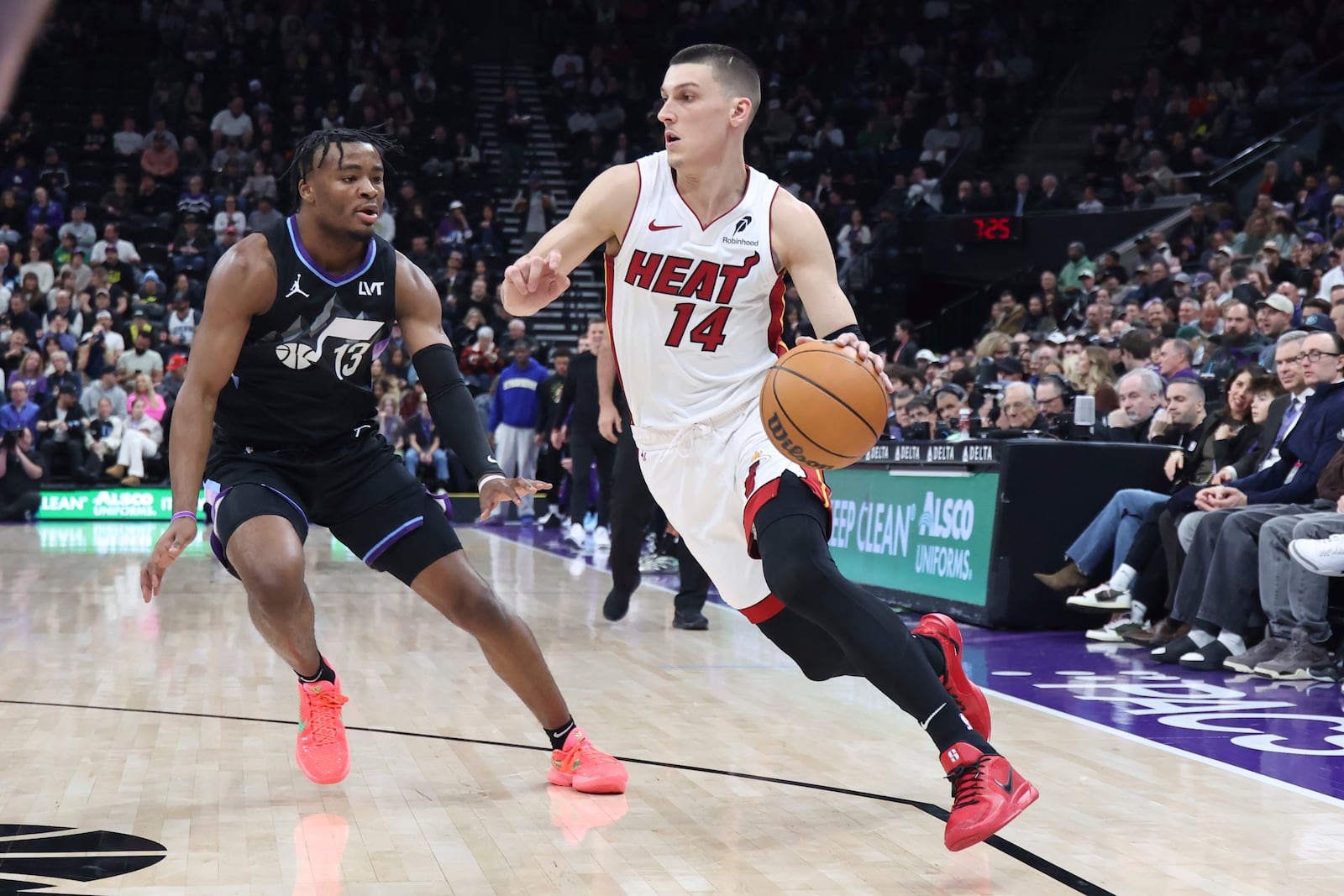 Miami Heat guard Tyler Herro (14) drives to the basket against Utah Jazz guard Isaiah Collier (13) during the first quarter of an NBA basketball game, Thursday, Jan. 9, 2025, in Salt Lake City. (AP Photo/Rob Gray)