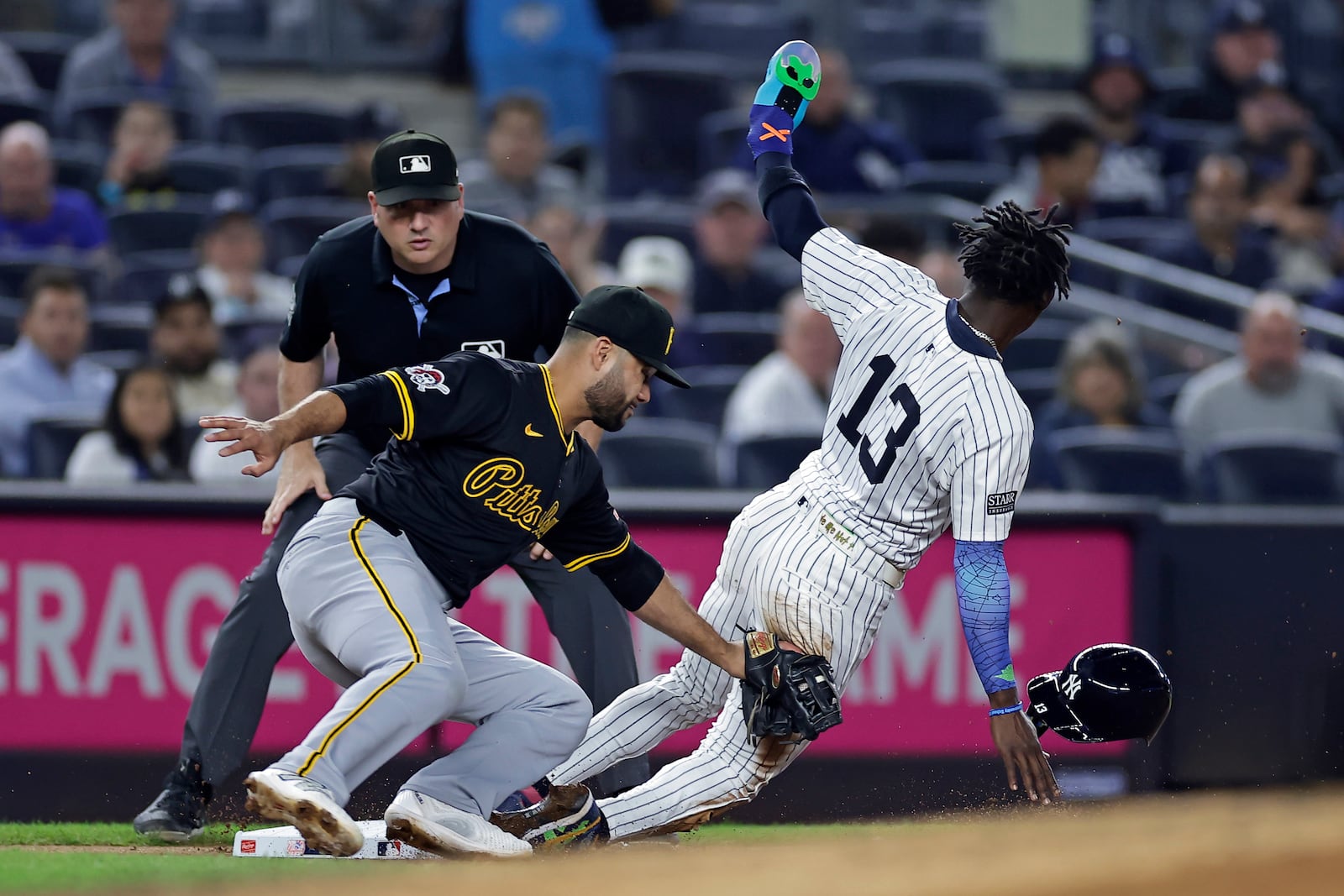 New York Yankees' Jazz Chisholm Jr. (13) steals third ahead of a tag by Pittsburgh Pirates third baseman Isiah Kiner-Falefa, front left, during the first inning of a baseball game Friday, Sept. 27, 2024, in New York. (AP Photo/Adam Hunger)