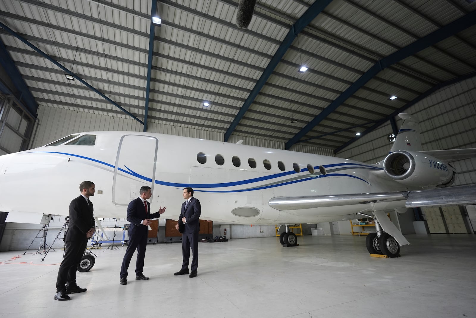 U.S. Secretary of State Marco Rubio, right, listens to Edwin F. Lopez, the attaché for DHS Homeland Security Investigations, center, next to the Venezuelan government airplane that Rubio announced is being seized by the U.S. during a news conference at La Isabela International Airport in Santo Domingo, Dominican Republic, Thursday, Feb. 6, 2025. At left is Dominican Public Prosecutor Enmanuel Ramirez. (AP Photo/Mark Schiefelbein, Pool)