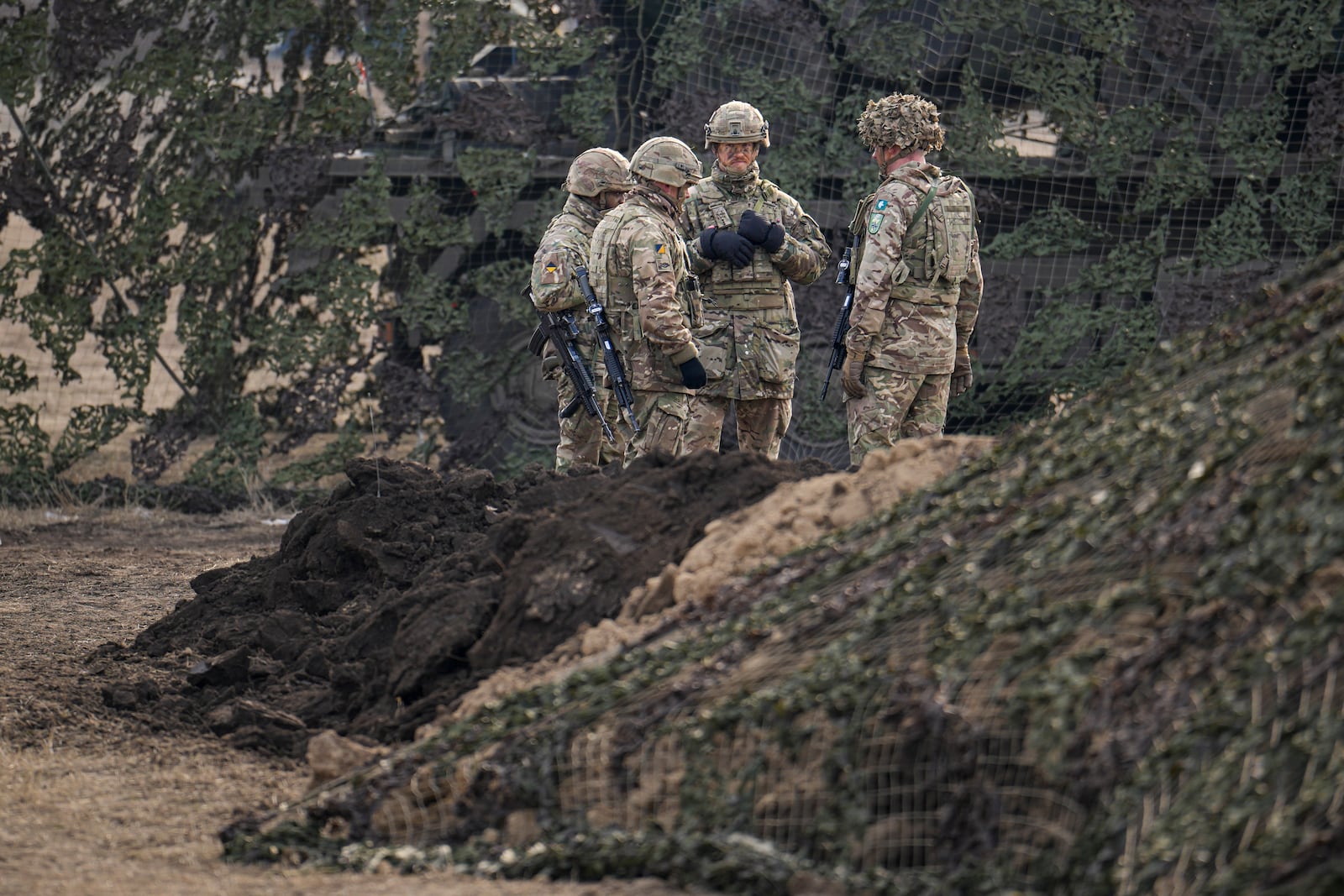 Servicemen stand at the end of the Steadfast Dart 2025 exercise, involving some 10,000 troops in three different countries from nine nations and represent the largest NATO operation planned this year, at a training range in Smardan, eastern Romania, Wednesday, Feb. 19, 2025. (AP Photo/Vadim Ghirda)