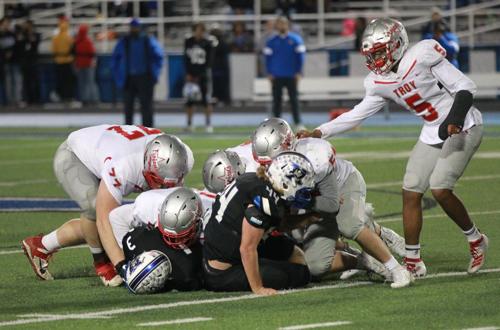 The Troy defense takes down Kevin Johnson (3) and Andrew Pollender (44) of Xenia. Xenia defeated visiting Troy 24-22 in a Week 9 high school football game on Friday, Oct. 25, 2019. MARC PENDLETON / STAFF