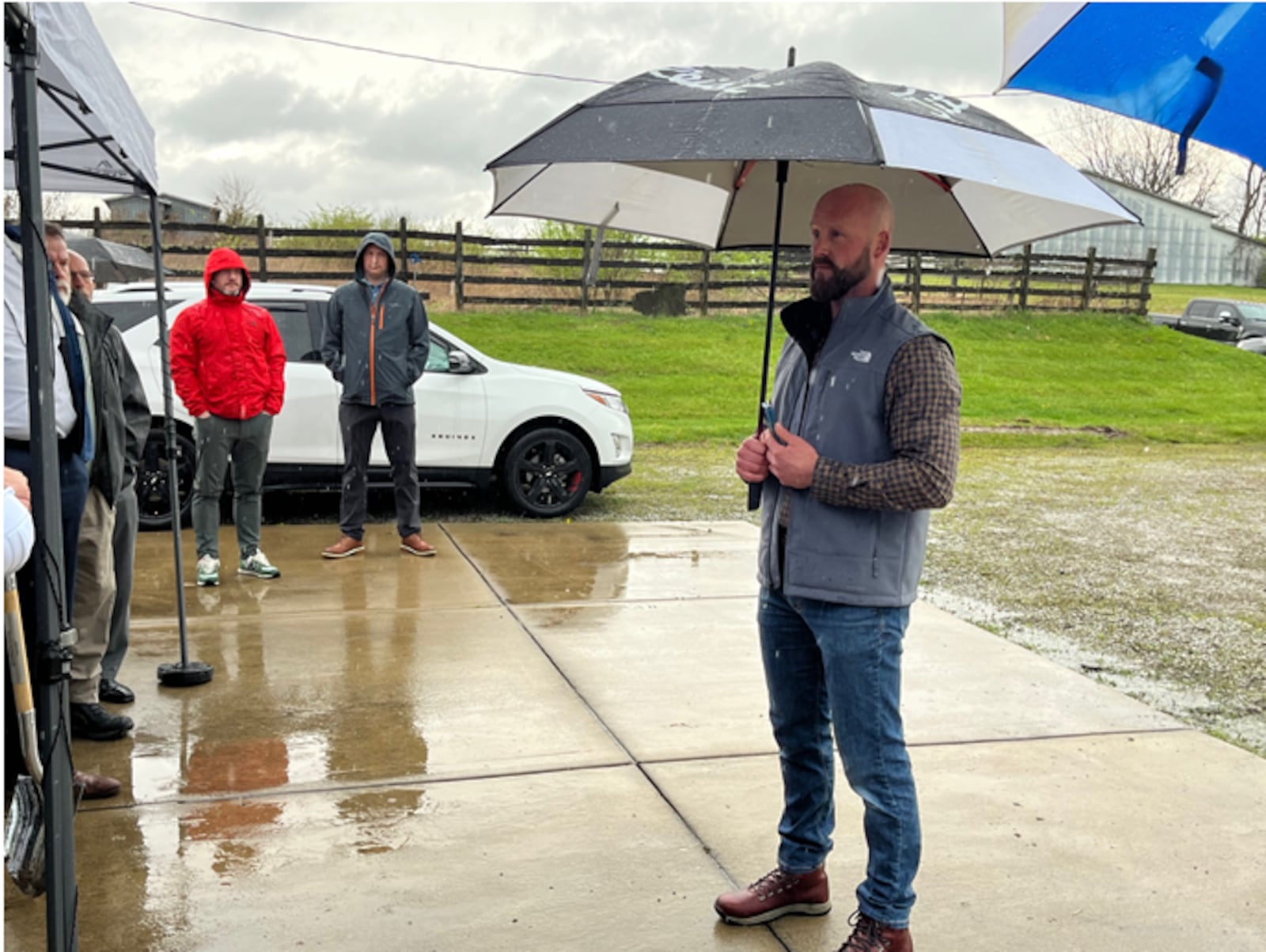 Lebanon Mayor Mark Messer delivers remarks at the groundbreaking ceremony for the Parkside at Lebanon project. Representatives from the city of Lebanon and Doyle Hughes Development pose with  their shovels before breaking ground for the $450 million Parkside at Lebanon development on Ohio 63. The heavy rain on Tuesday, April 2, 2024 did not stop the ceremony.  ED RICHTER/STAFF