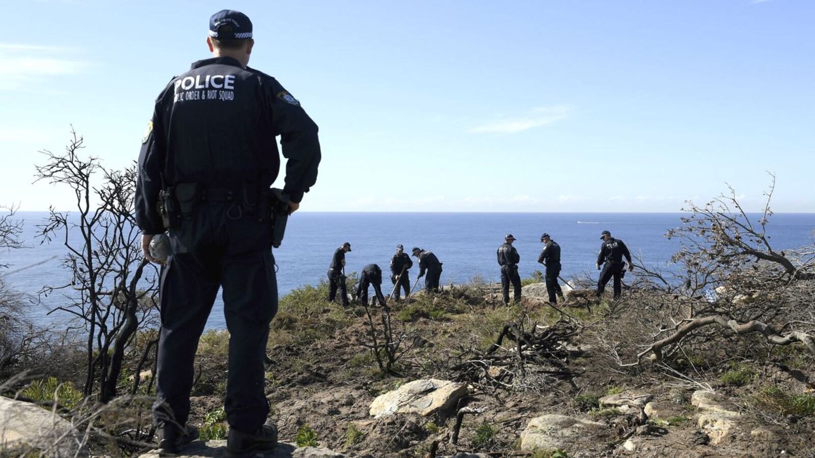 New South Wales police search a headland in Sydney, Australia, Tuesday, May 12, 2020, following the arrest of a suspect in the cold case death of American mathematician Scott Johnson. Johnson, 27, was found dead Dec. 10, 1988, at the bottom of the cliff in what authorities believe was a gay hate crime.