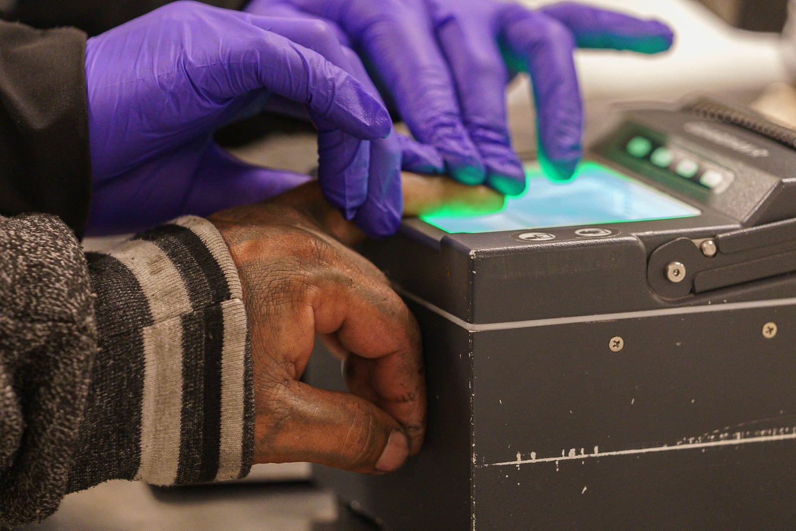 FILE - An immigrant considered a threat to public safety and national security has his fingerprints scanned as he is processed for deportation by U.S. Immigration and Customs Enforcement agents at the ICE Metropolitan Detention Center in Los Angeles, June 6, 2022. (AP Photo/Damian Dovarganes, File)