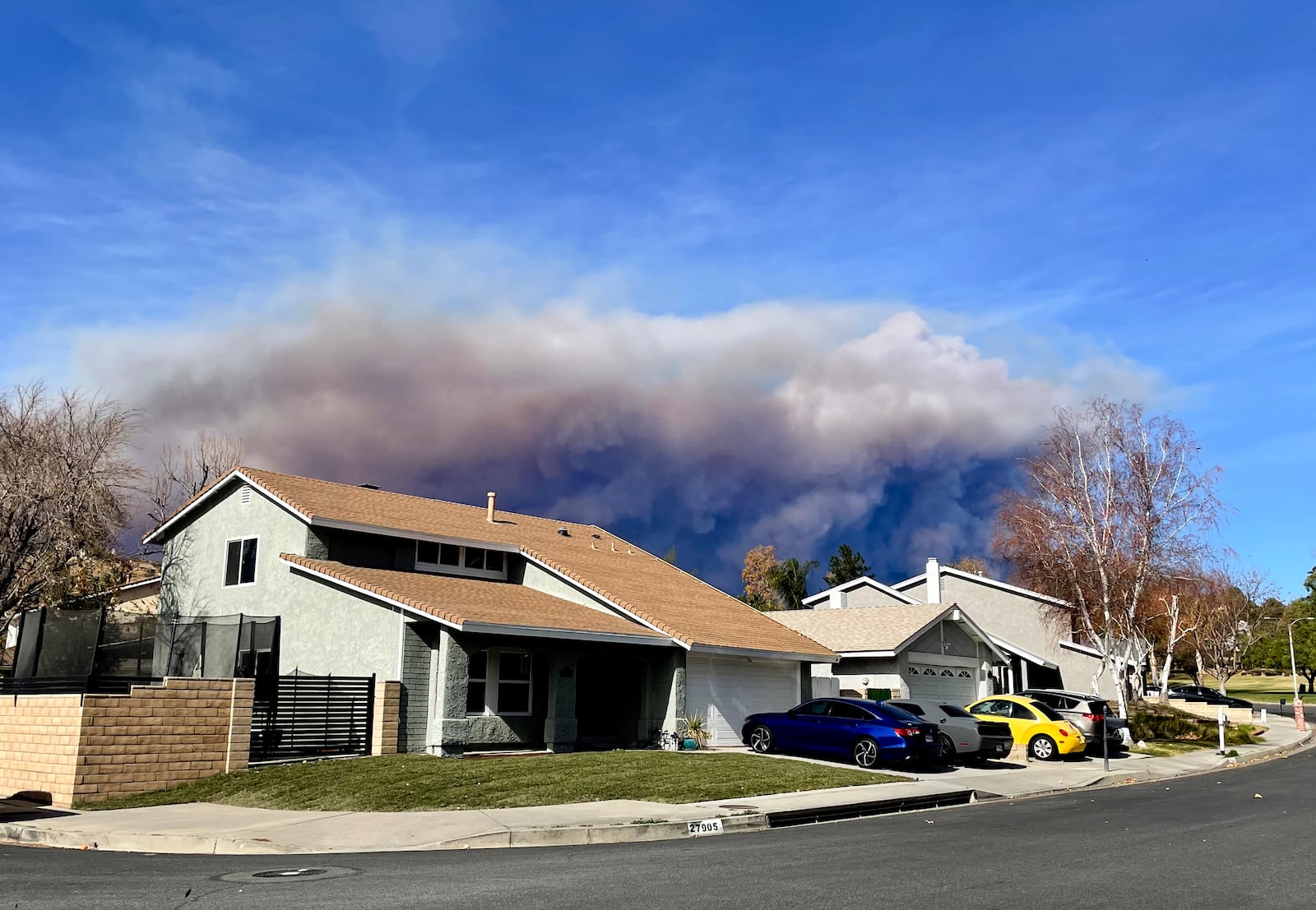 A large plume of smoke caused by the Hughes Fire rises from Castaic Lake as seen from a neighborhood of Santa Clarita, Calif., Wednesday, Jan. 22, 2025. (AP Photo/Marcio Jose Sanchez)