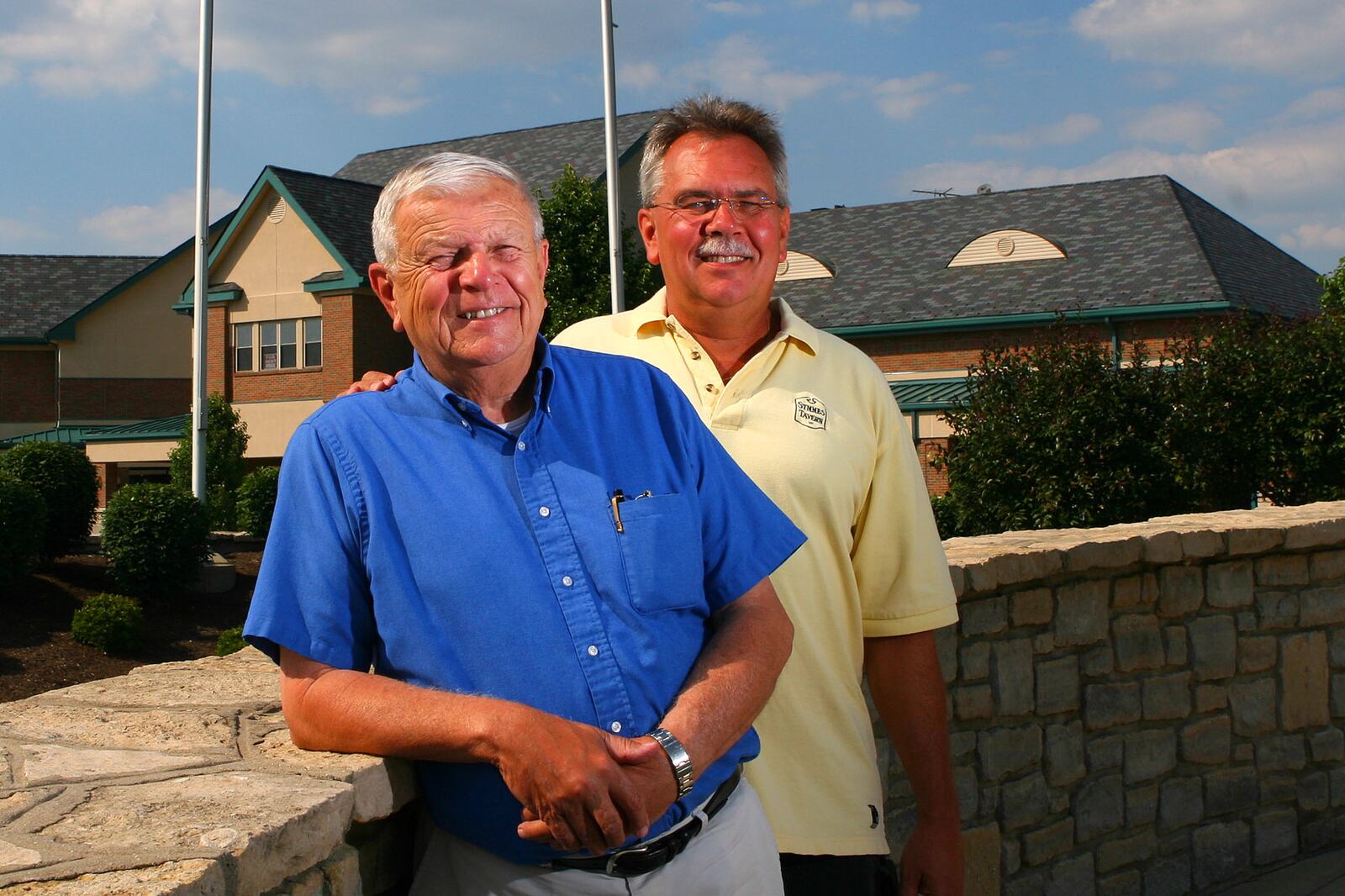 FILE PHOTO: Joe Schwarz, left, poses with his son, Jo Jo, Tuesday, June 12, 2007, at the Village Green on Wessel Drive in Fairfield, Ohio. The father-son team are owners of JII Homes, whose office is housed in the building behind them, a business that builds homes, develops land and manages properties. NICK GRAHAM/FILE (2007)