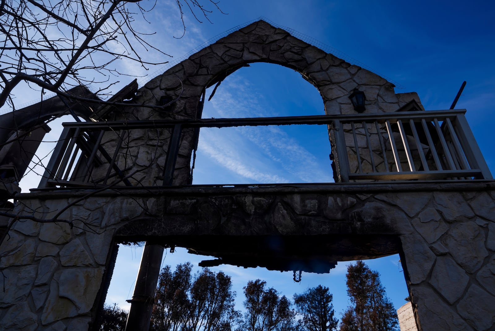 The front wall of a destroyed residence is seen as President Donald Trump tours the Palisades Fire zone damage in the Pacific Palisades neighborhood of Los Angeles Friday, Jan. 24, 2025. (AP Photo/Damian Dovarganes)