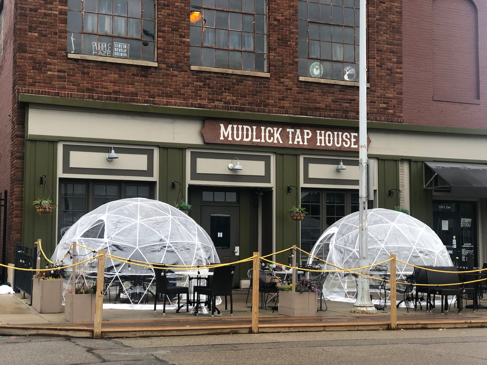 Mudlick Tap House in downtown Dayton installed plastic igloos on its patio to keep guests safe during the pandemic. CORNELIUS FROLIK / STAFF