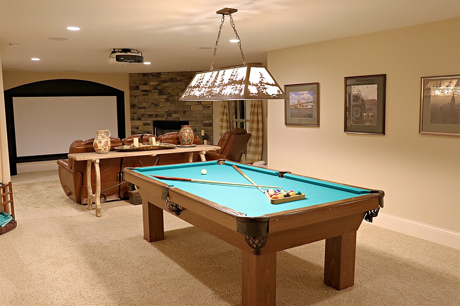 The finished lower level includes an open floor plan with space for a media, gaming and wine-tasting. A stone, gas fireplace is tucked into one corner and a full-wall screen built in for the projection system. On the opposite end, a wet bar area has the matching stone backsplash above granite countertops. CONTRIBUTED PHOTO BY KATHY TYLER