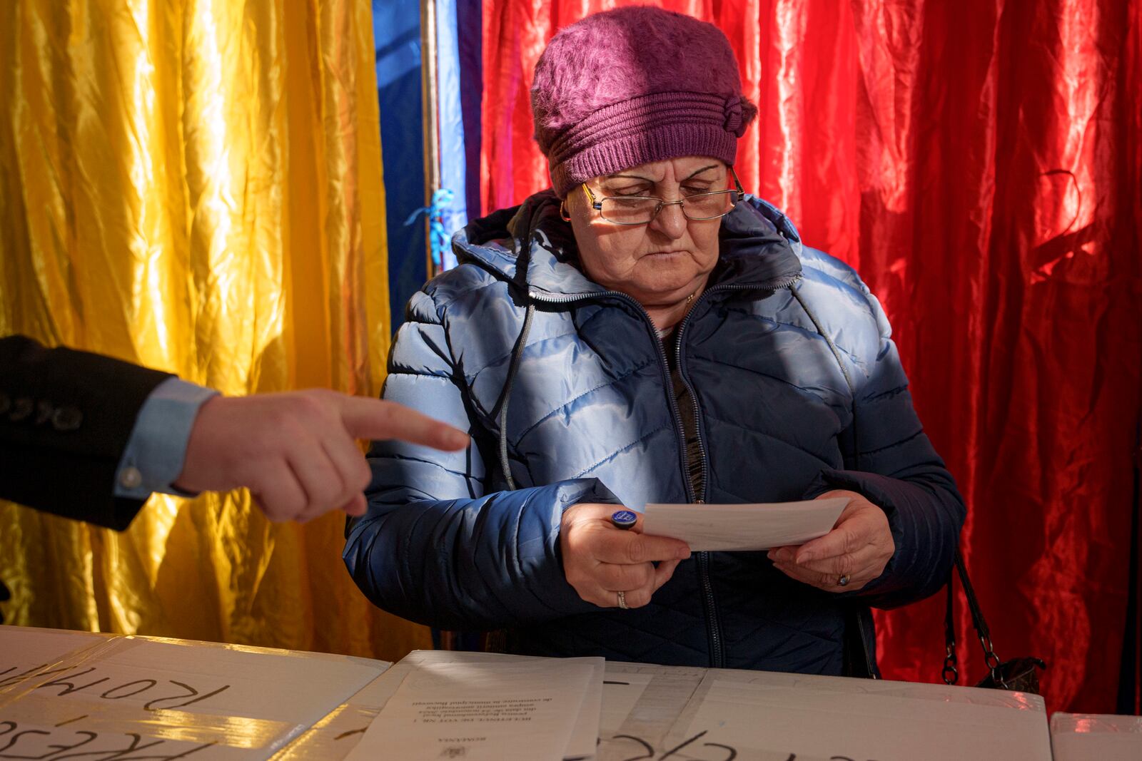 A woman prepares to cast her vote in the country's presidential elections, in Bucharest, Romania, Sunday, Nov. 24, 2024. (AP Photo/Andreea Alexandru)