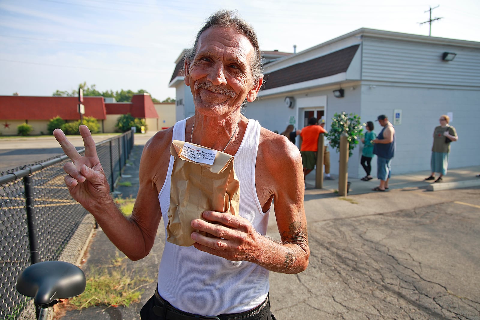 David Blystone, from Springfield, holds up his bag of pot after being the first person in line at The Forest in Springfield Tuesday, Aug. 6, 2024. BILL LACKEY/STAFF