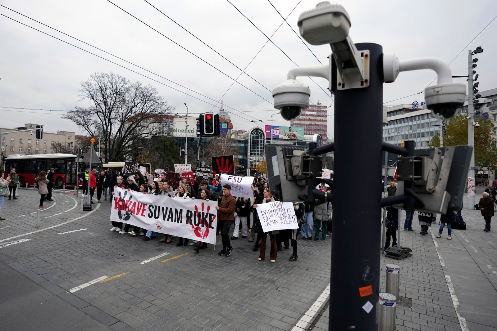 People hold a banner that reads "You have blood on your hands" and stop traffic during a silent protest to commemorate the 15 victims of a railway roof collapse six weeks ago, demand accountability for the tragedy, in Belgrade, Serbia, Friday, Dec. 13, 2024. (AP Photo/Darko Vojinovic)