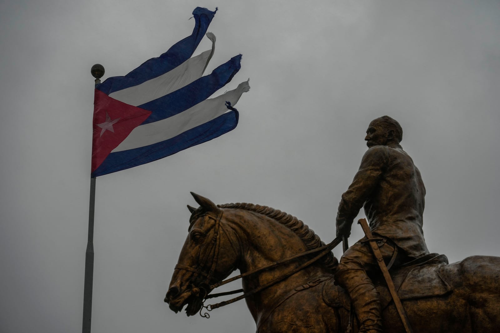 A Cuban flag shredded by the winds of Hurricane Rafael flies above the statue of General Calixto Garcia in Havana, Cuba, Wednesday, Nov. 6, 2024. (AP Photo/Ramon Espinosa)